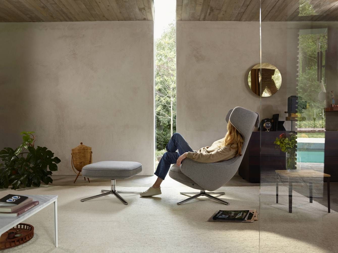 Frau entspannt im grauen Vitra Grand Repos Sessel mit Ottoman, Premium Leder und Kontrastnaht.