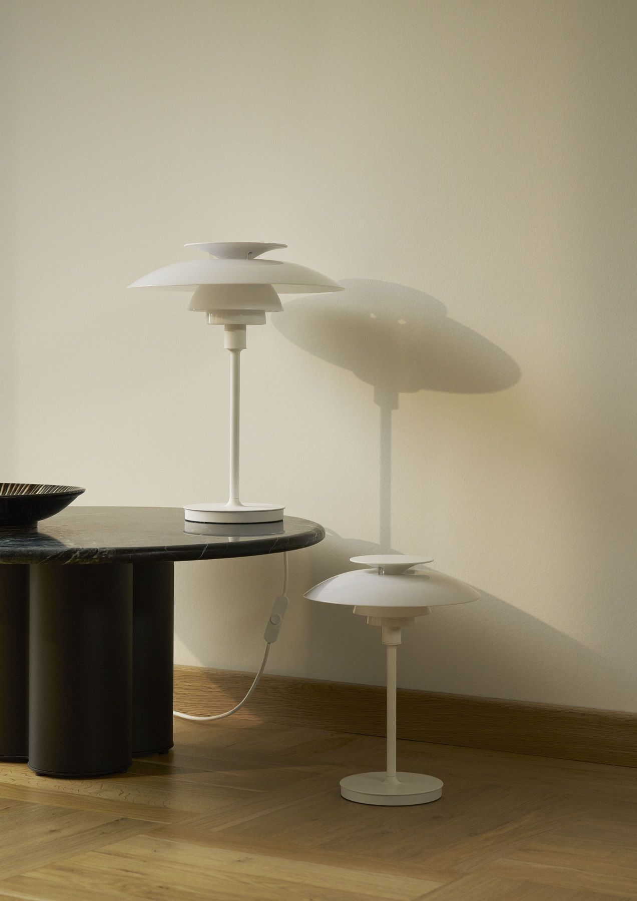 Weiße PH 80 Tischleuchte von Louis Poulsen auf einem Tisch, modernes Design für Wohnzimmer.