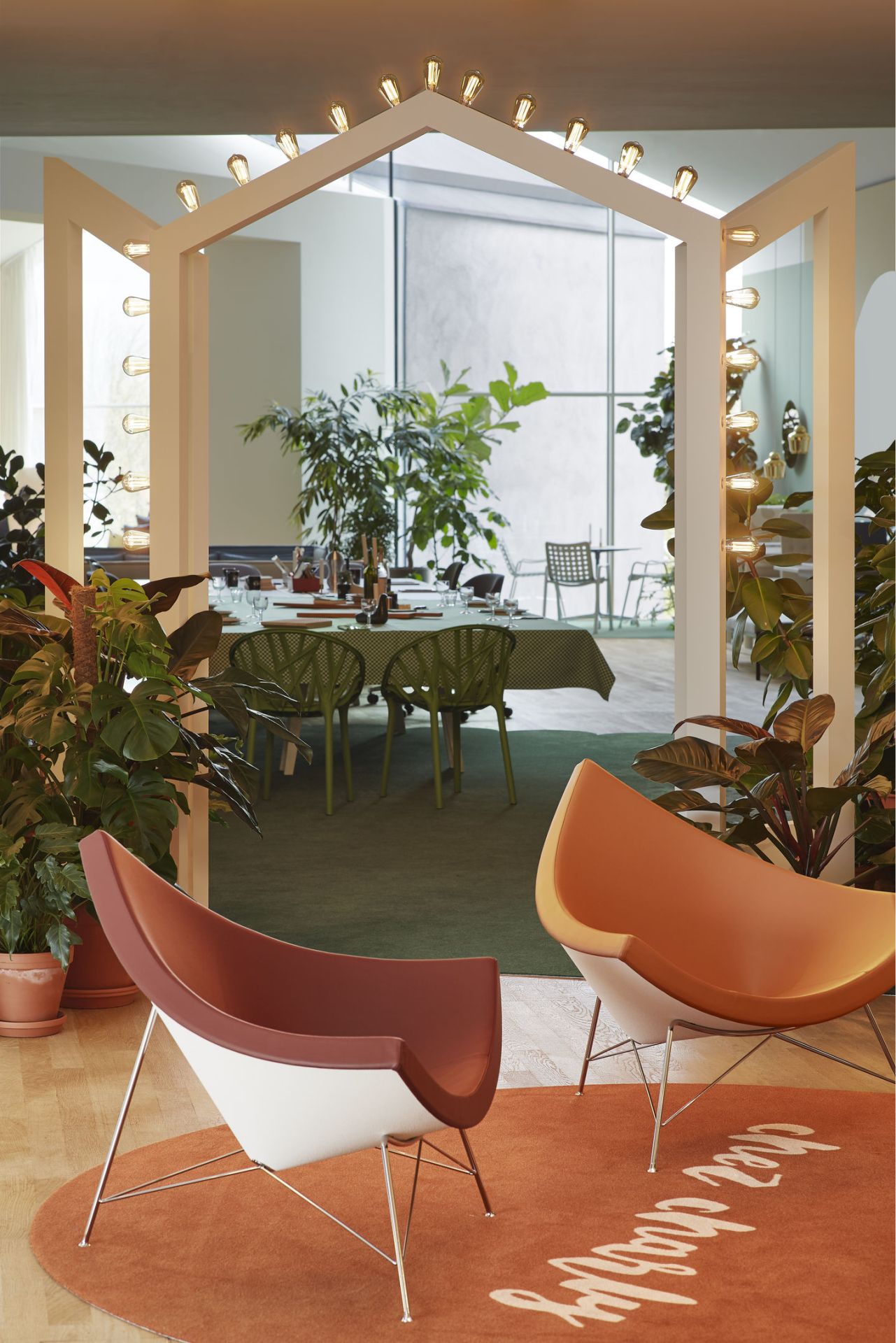 Zwei Coconut Chairs von Vitra in einem stilvollen Wohnzimmer mit Pflanzen und Esstisch.