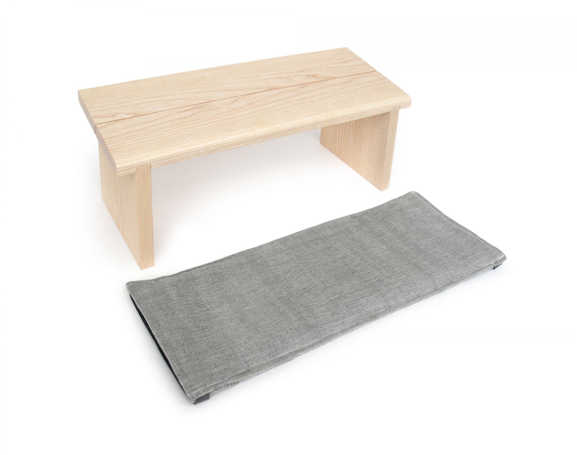 Meditationsbank aus Holz mit grauem Meditationskissen für bequemes, entspanntes Sitzen bei der Meditation.