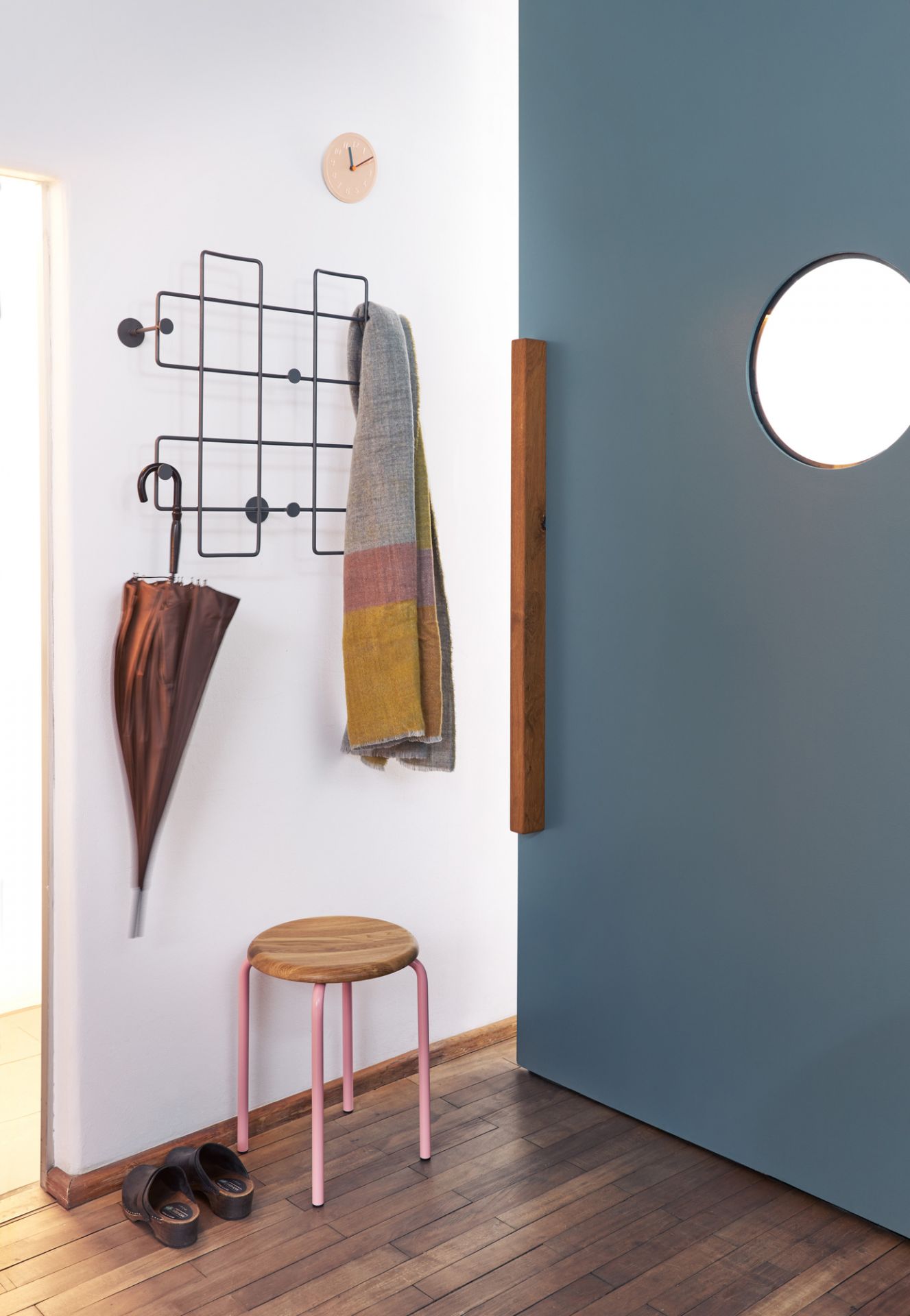 Richard Lampert Stapelhocker: Holz-Sitzhocker mit rosafarbenem Gestell im Flur mit Garderobe und Schirm.