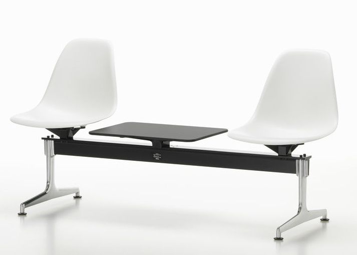 Eames Plastic Side Chair RE auf Traverse von Vitra mit weißen Sitzschalen und schwarzem Tisch.