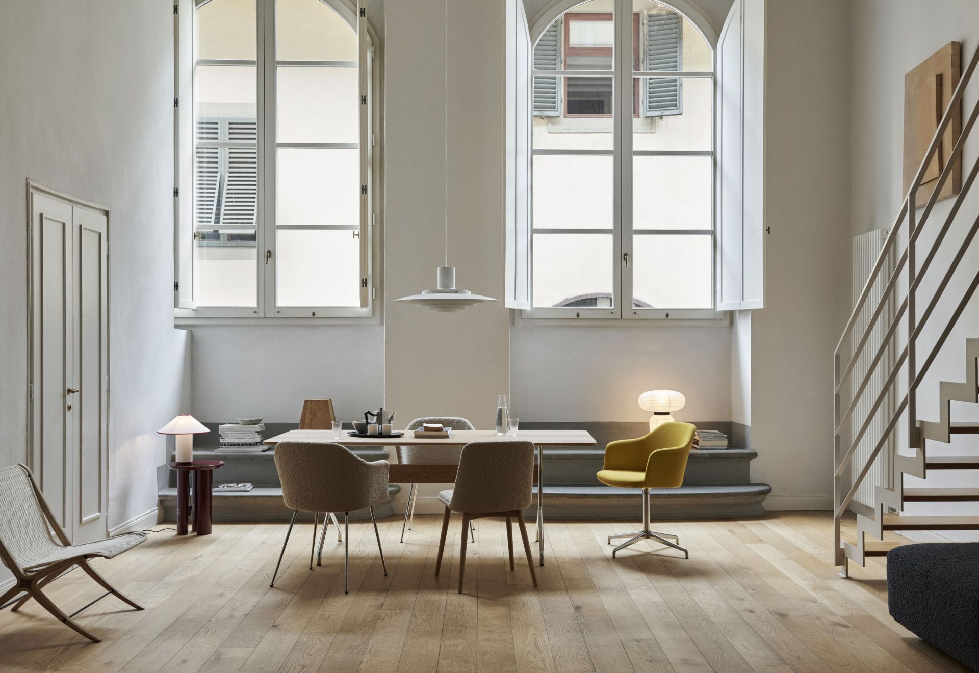 AndTradition ATD6 Colette Tischleuchte auf einem Tisch in einem hellen, modern eingerichteten Wohnzimmer.