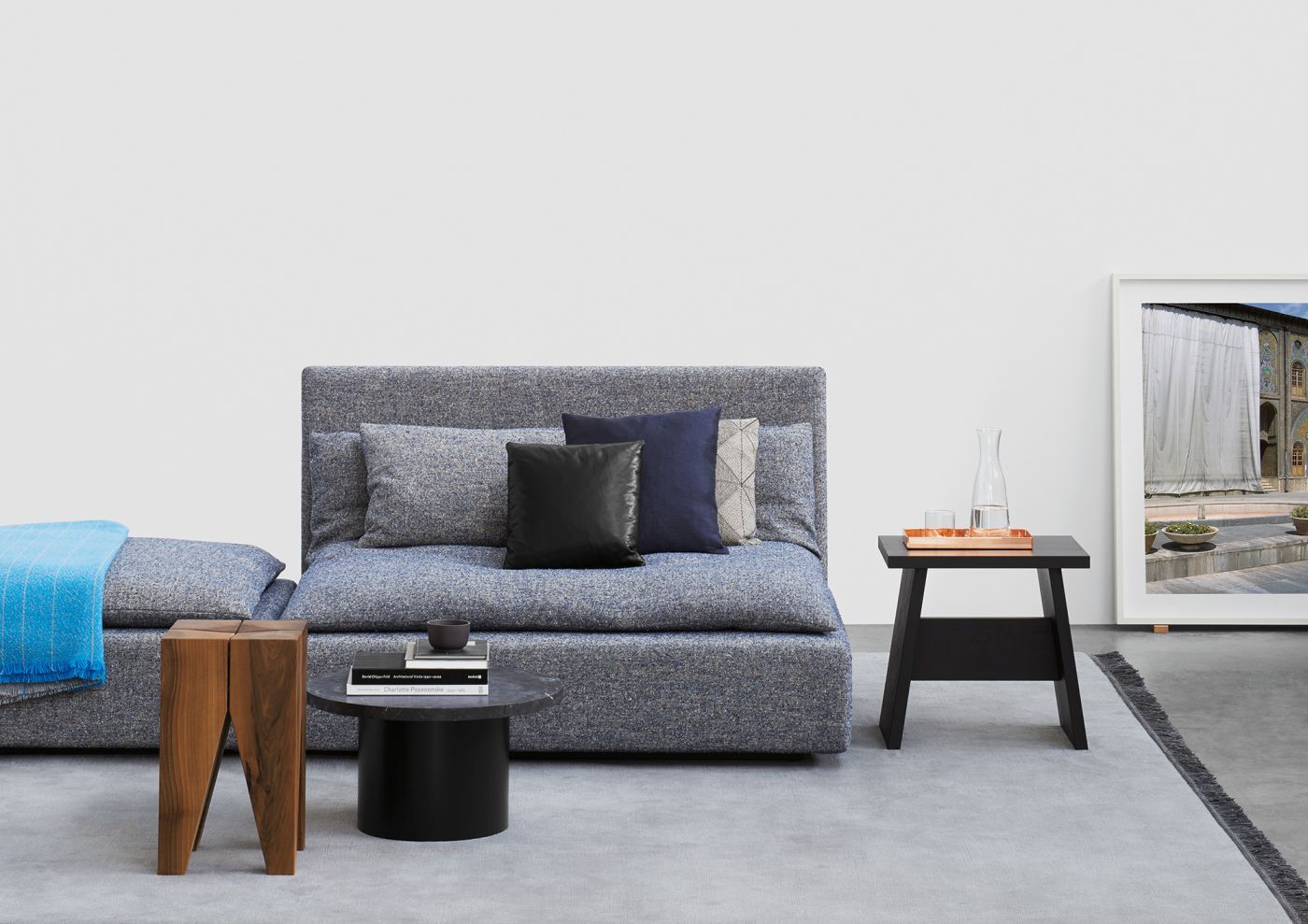 Enoki Beistelltisch CT09 von e15 aus Holz, neben Sofa mit Kissen und Deko.