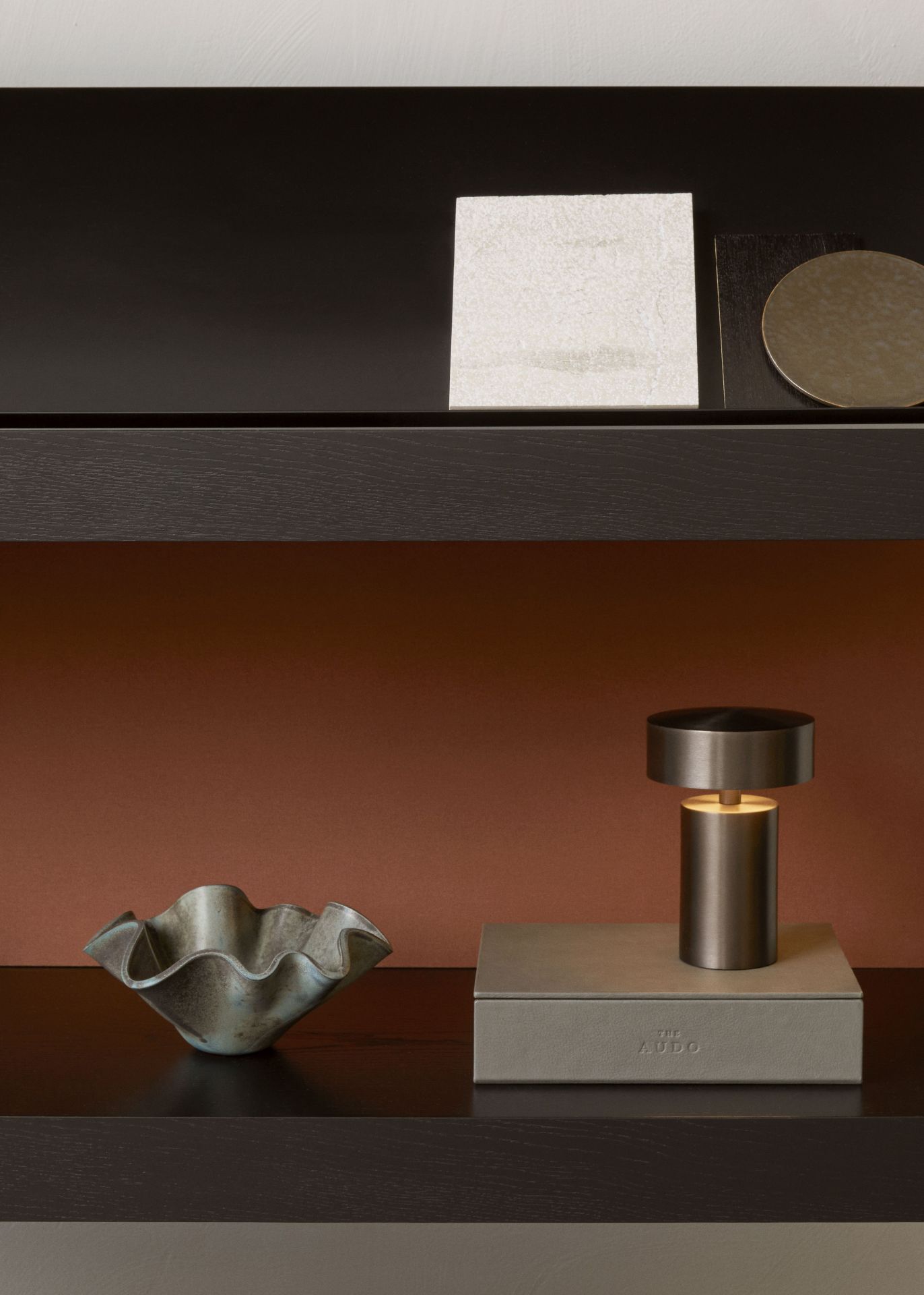 Detailaufnahme eines Audo Copenhagen Regals mit dekorativen Elementen wie Lampe und Schale.