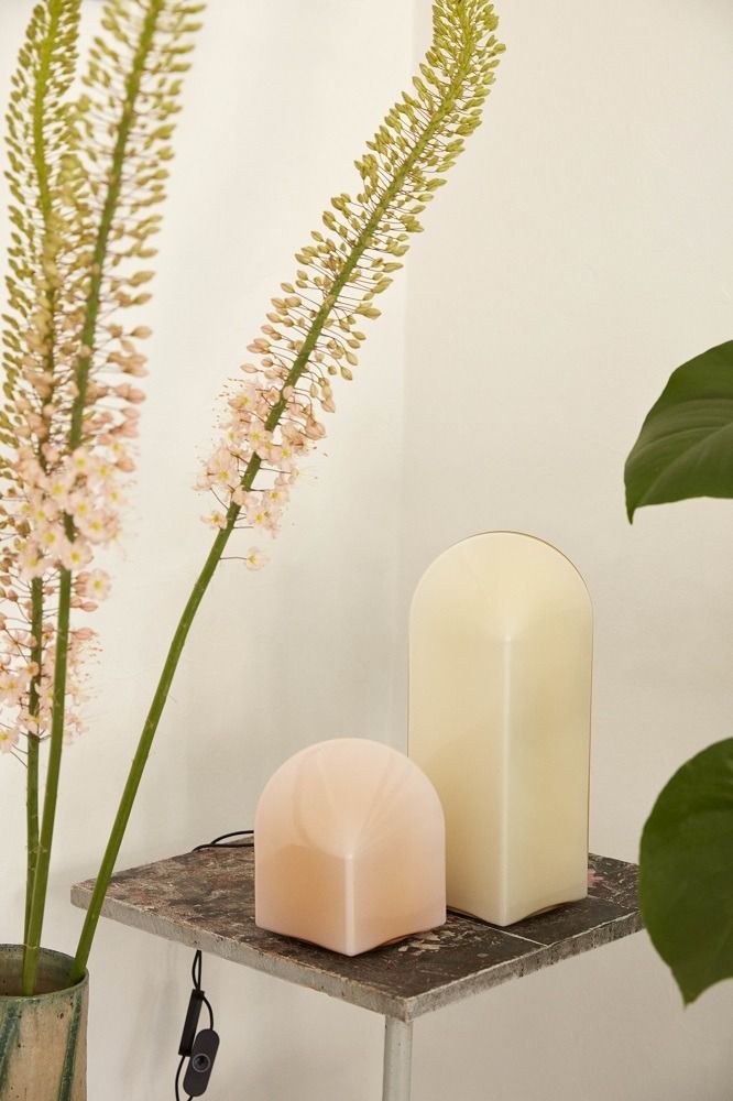 Zwei Hay Parade Table Lamp Tischleuchten in Beige und Rosa auf einem Regal mit Dekoration.