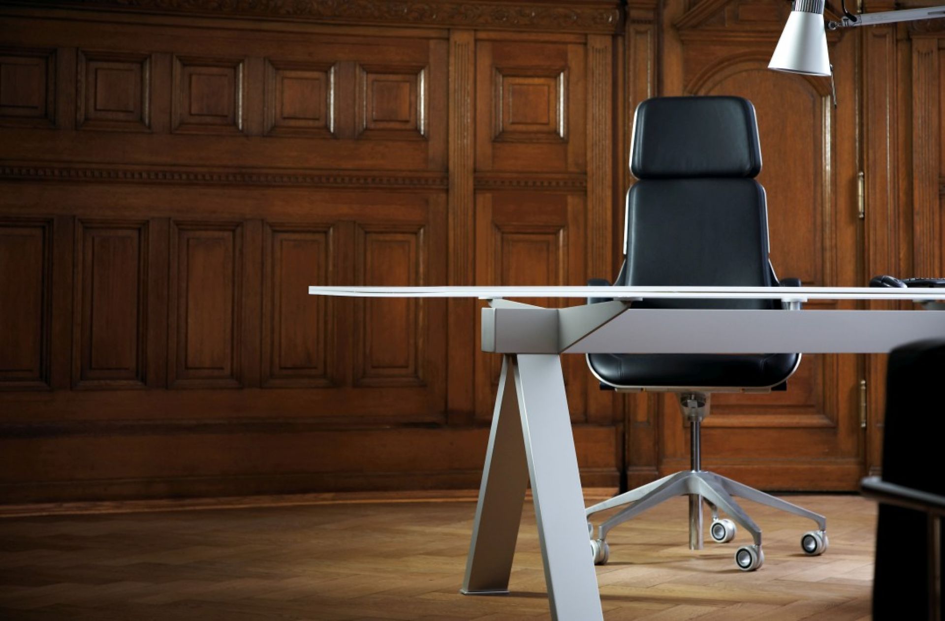 Interstuhl Silver SV11P Bürodrehstuhl hoch in Schwarz vor einer holzvertäfelten Wand und Schreibtisch.