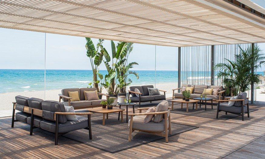Emu Twins Sofa Outdoor Lounge-Set auf Holzterrasse mit Meerblick, moderne Gartenmöbel für Entspannung.