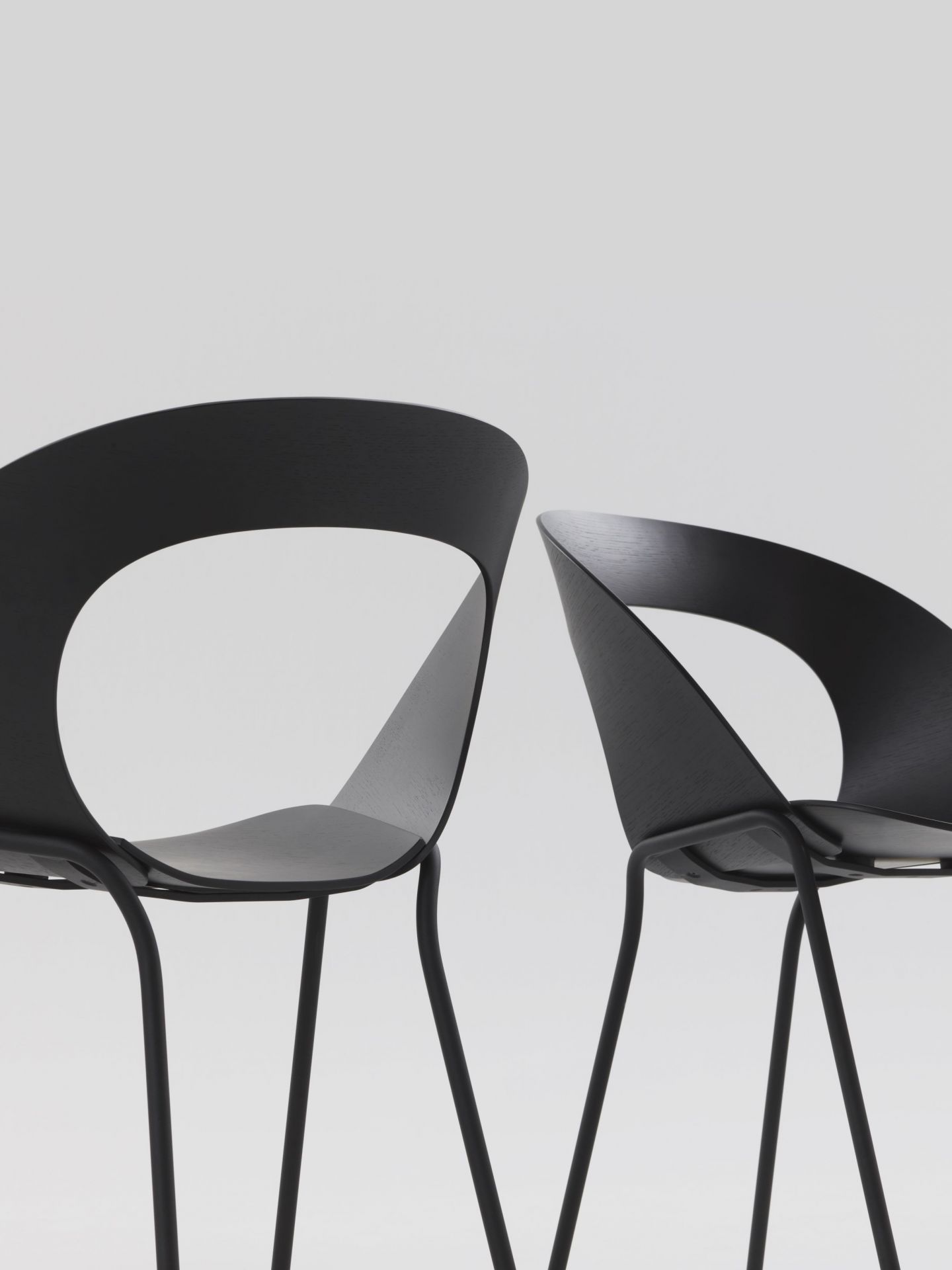 Zwei schwarze Brunner Mudra Stühle mit minimalistischem Design und Stahlbeinen vor neutralem Hintergrund.
