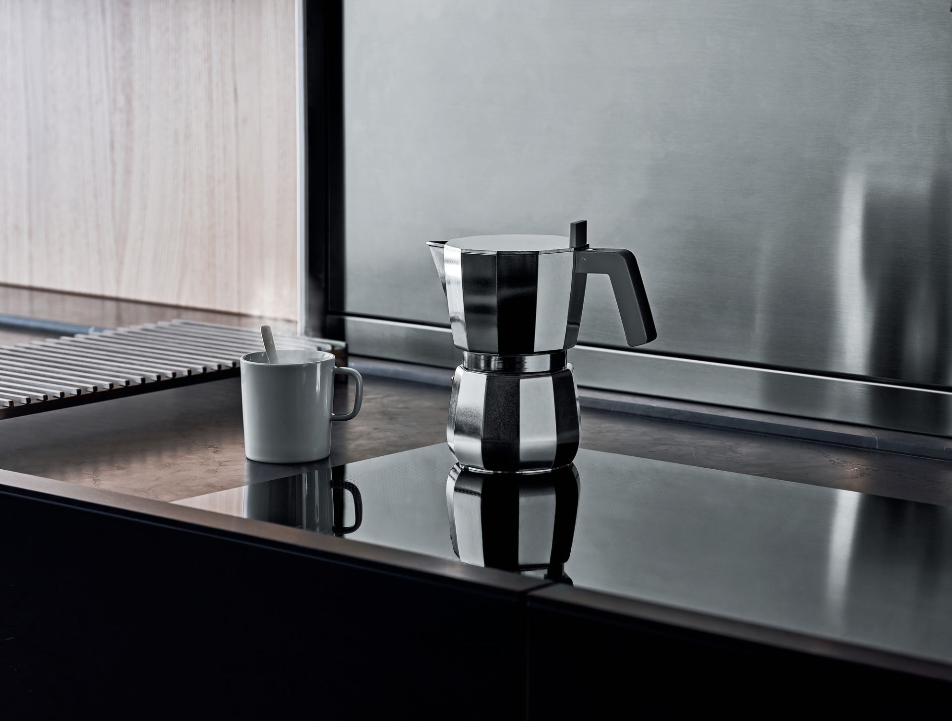 Alessi Moka Espressokocher DC06 auf einer modernen Küchenoberfläche mit Tasse. Italienischer Kaffeekocher.