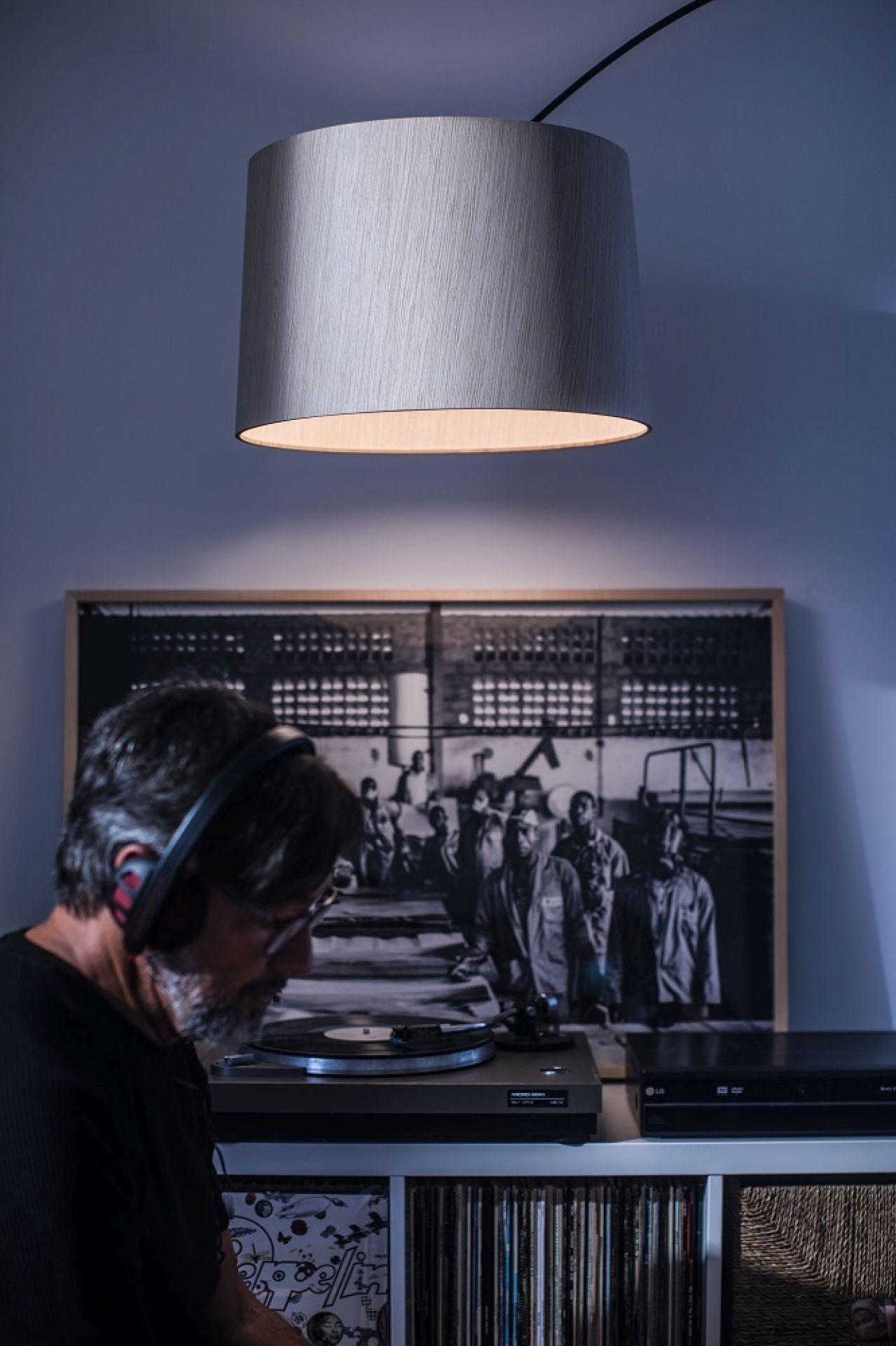 Twiggy Wood LED Stehleuchte von Foscarini über einem Mann mit Kopfhörern und Schallplattenspieler.