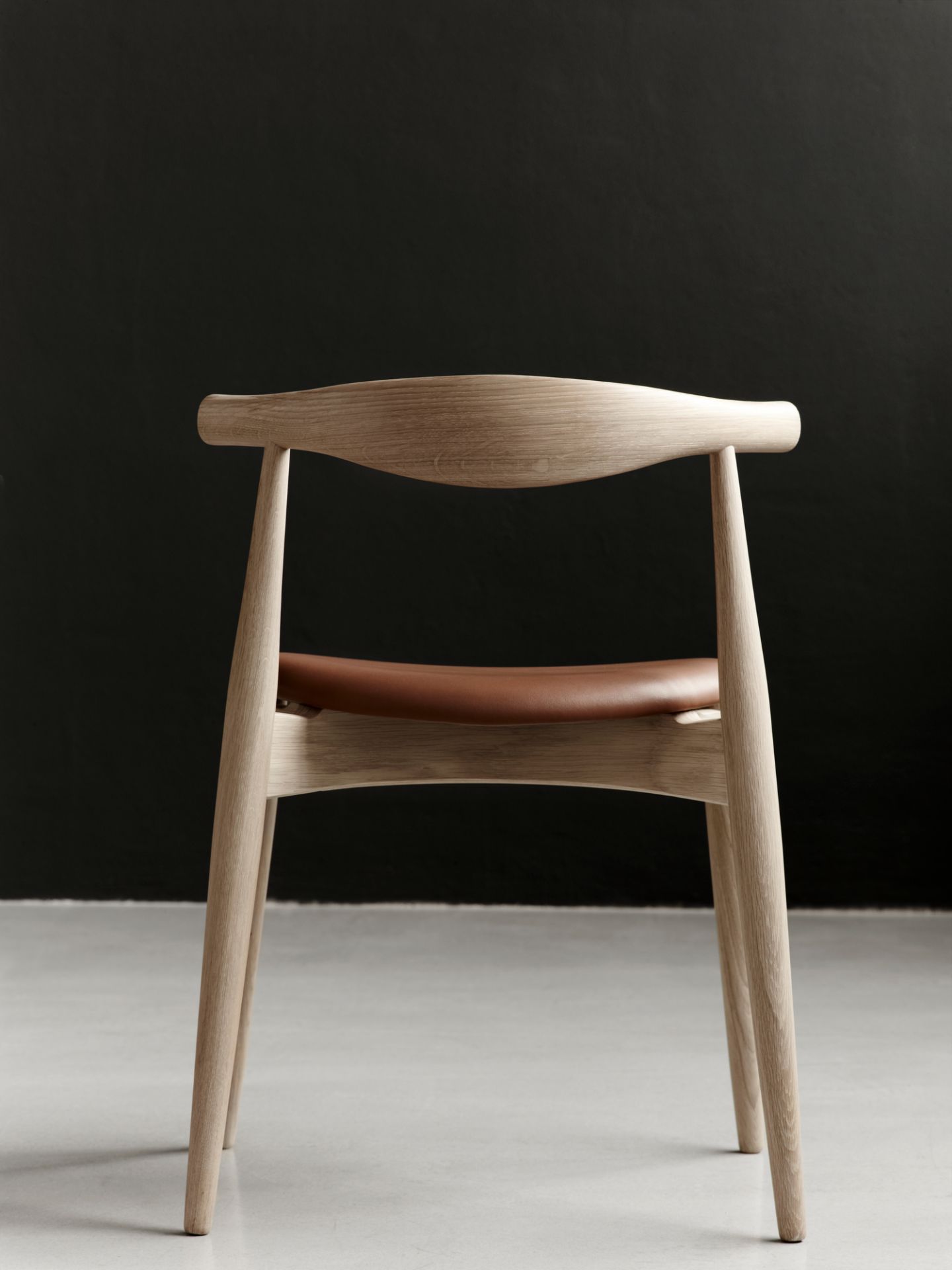 CH20 Elbow Stuhl mit Eichengestell und braunem Lederbezug, Ansicht von hinten. Designklassiker.