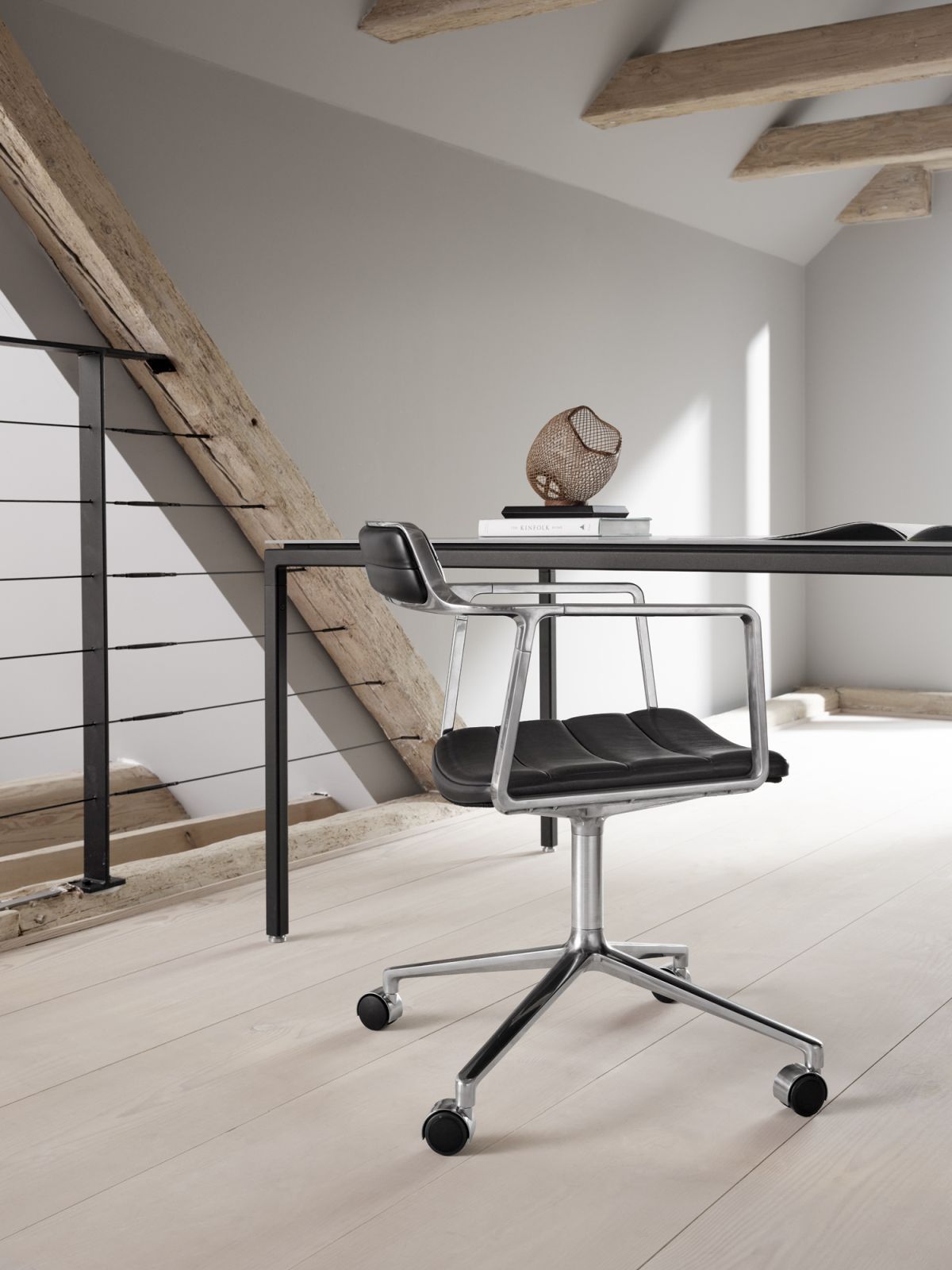 Vipp452 Swivel Stuhl mit Rollen, Leder Bürostuhl mit Armlehnen und silbernem Fußkreuz im modernen Büro.