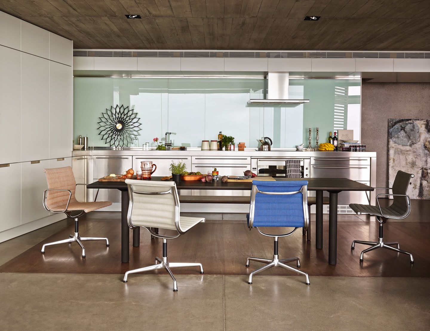 Esszimmer mit vier Aluminium Chair EA 104 Stühlen von Vitra in verschiedenen Farben.