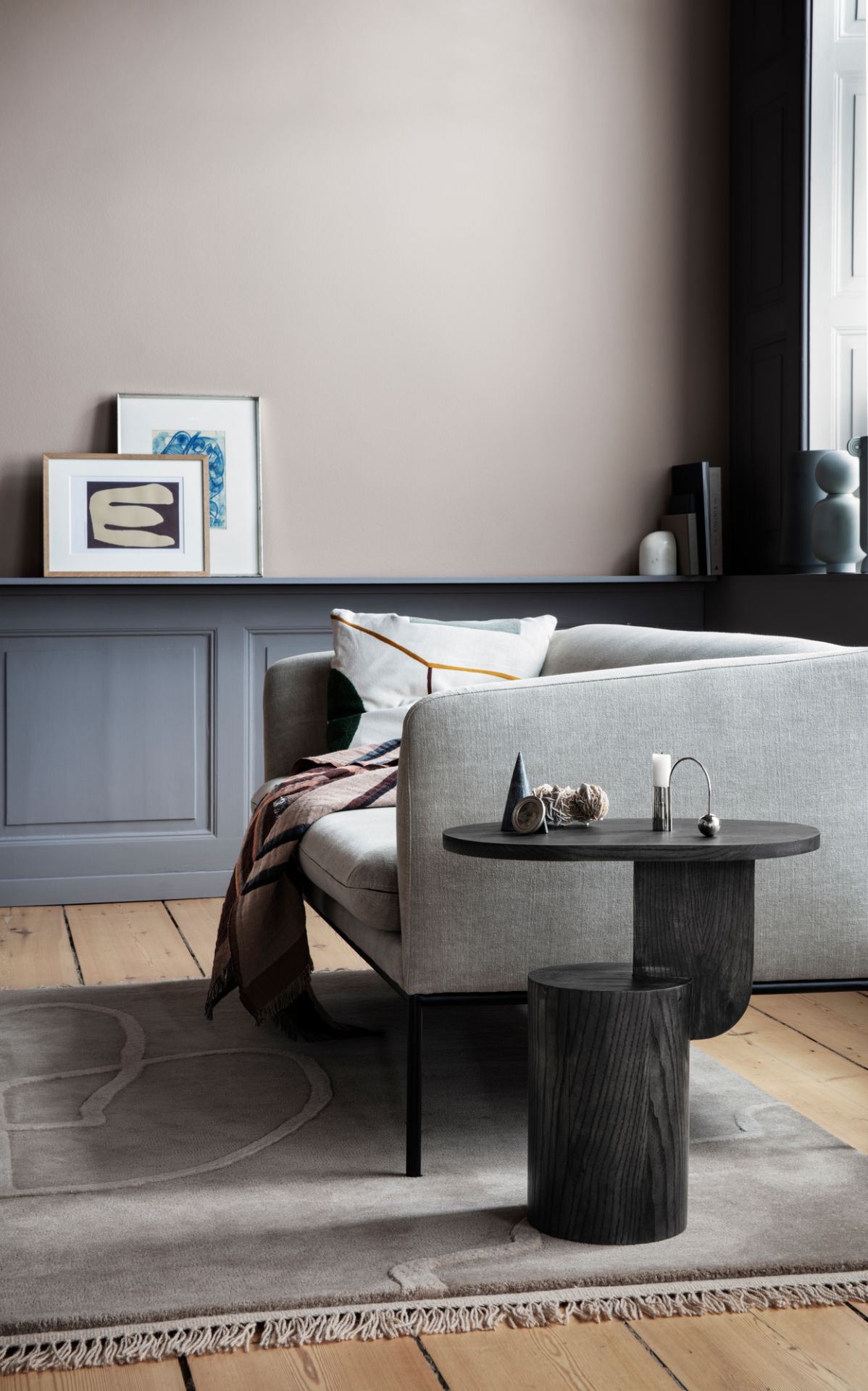 Ferm Living Insert Side Table: Dunkler Holz Beistelltisch im Wohnzimmer neben Sofa und Teppich.