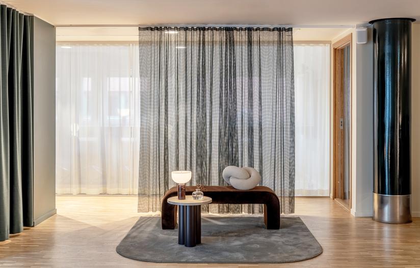 Moderner Wohnraum mit Normann Copenhagen Dit Coffee Table Beistelltisch, Lampe, Bank und grauem Teppich.