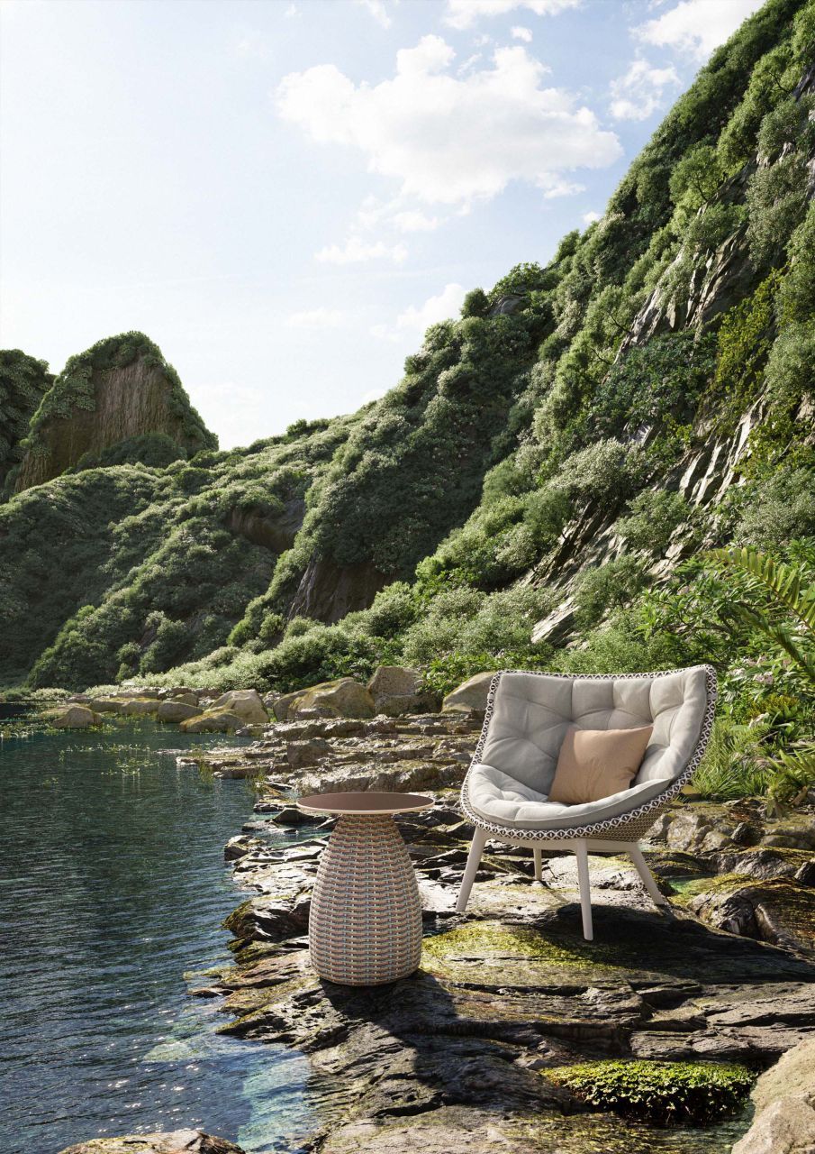 Mbrace Alu Lounge Sessel von Dedon mit Kissen und Beistelltisch am Seeufer.