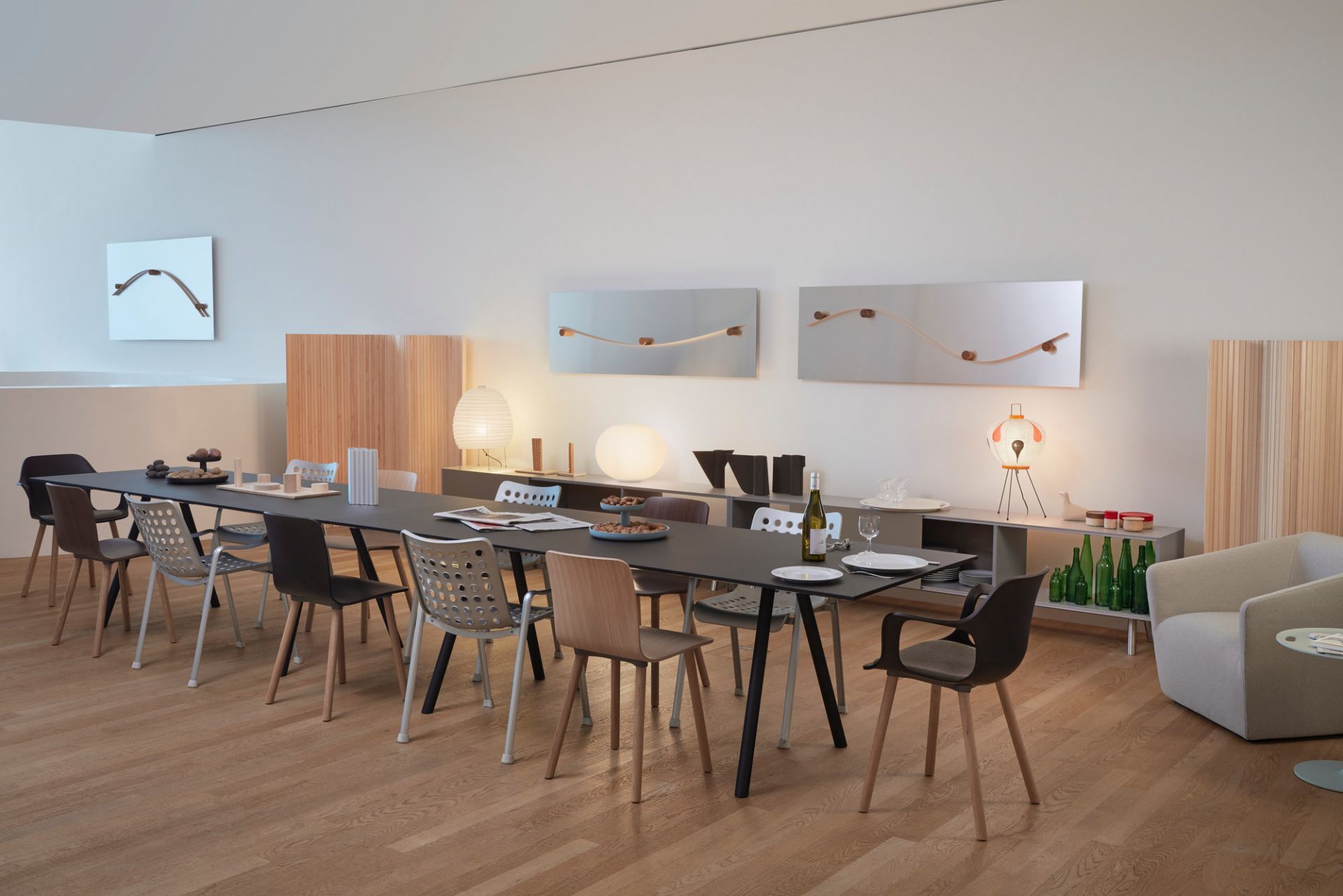Esszimmer mit langem Tisch und verschiedenen Vitra Hal Ply Wood Stühlen in modernem Design.