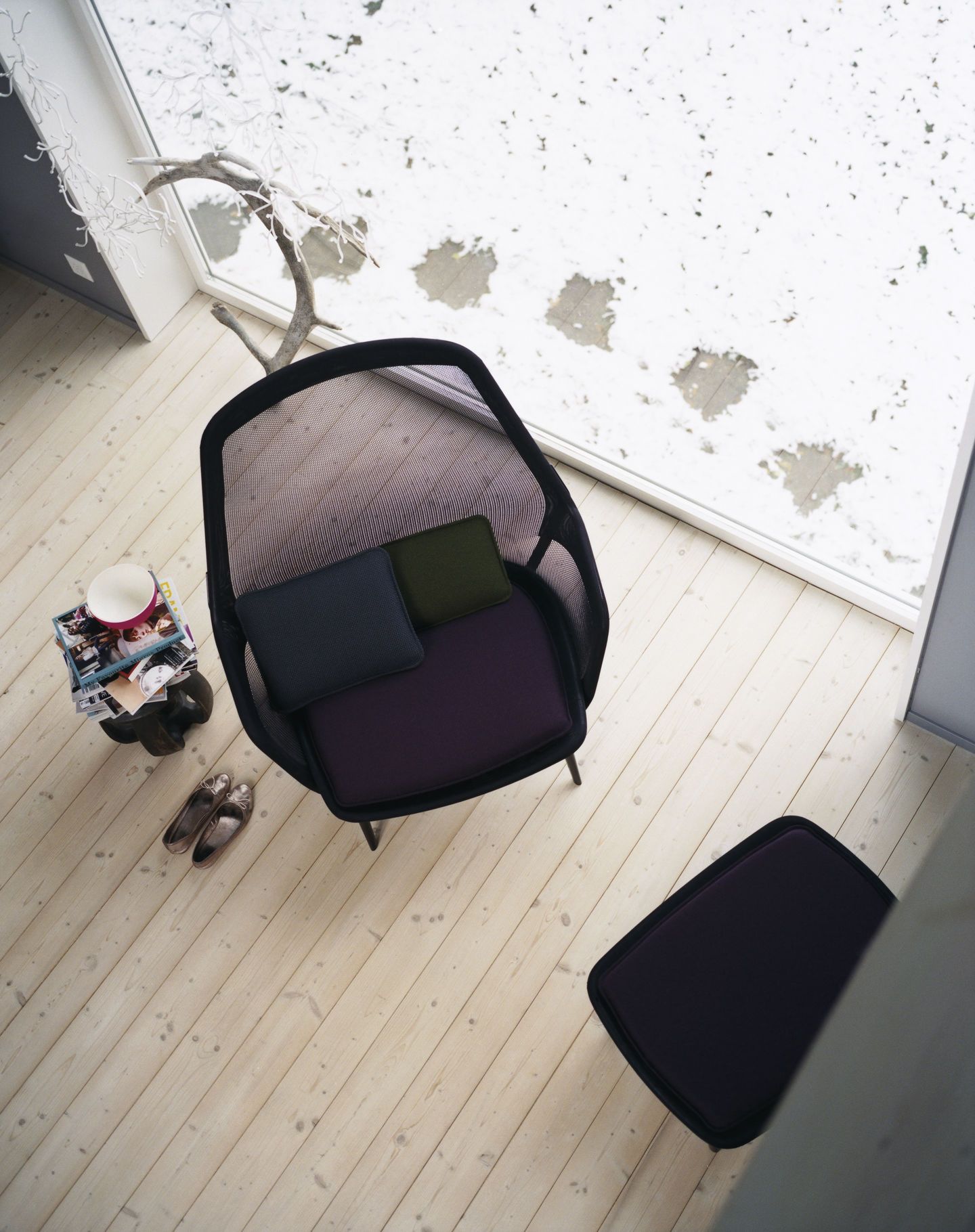 Vogelperspektive: Vitra Slow Chair Sessel mit Ottoman, Kissen und Blick auf verschneite Landschaft.