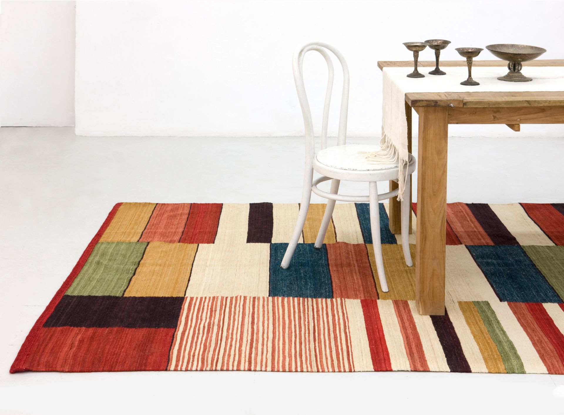 Farbenfroher Medina Teppich von Nanimarquina (200x300 cm) mit geometrischem Muster im Wohnzimmer.
