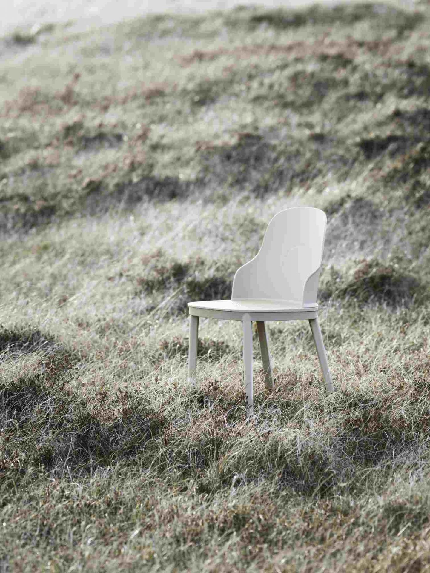 Heller Allez Chair PP Stuhl von Normann Copenhagen steht auf einer Wiese mit hohem Gras.