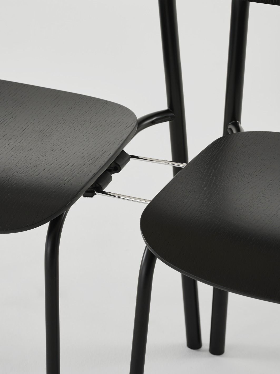Detailaufnahme von zwei schwarzen Thonet S 243 Stahlrohrstühlen mit olivgrünem Finish, modernes Möbeldesign für Esszimmer und Wohnbereich.