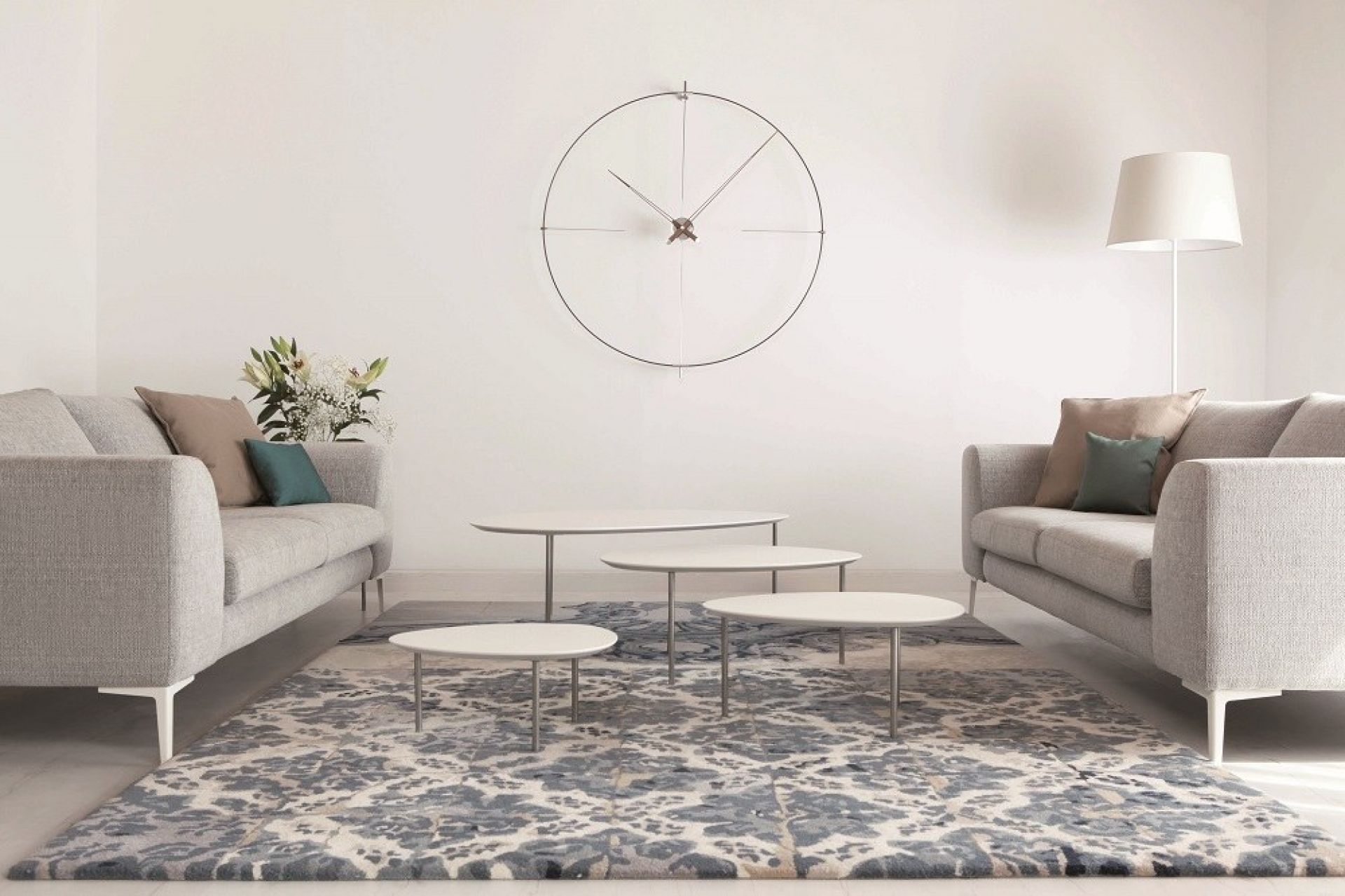Helle Wohnzimmer-Szene mit Bilbao Nomon Wanduhr, grauen Sofas, Couchtischen und gemustertem Teppich für modernes Interieur.