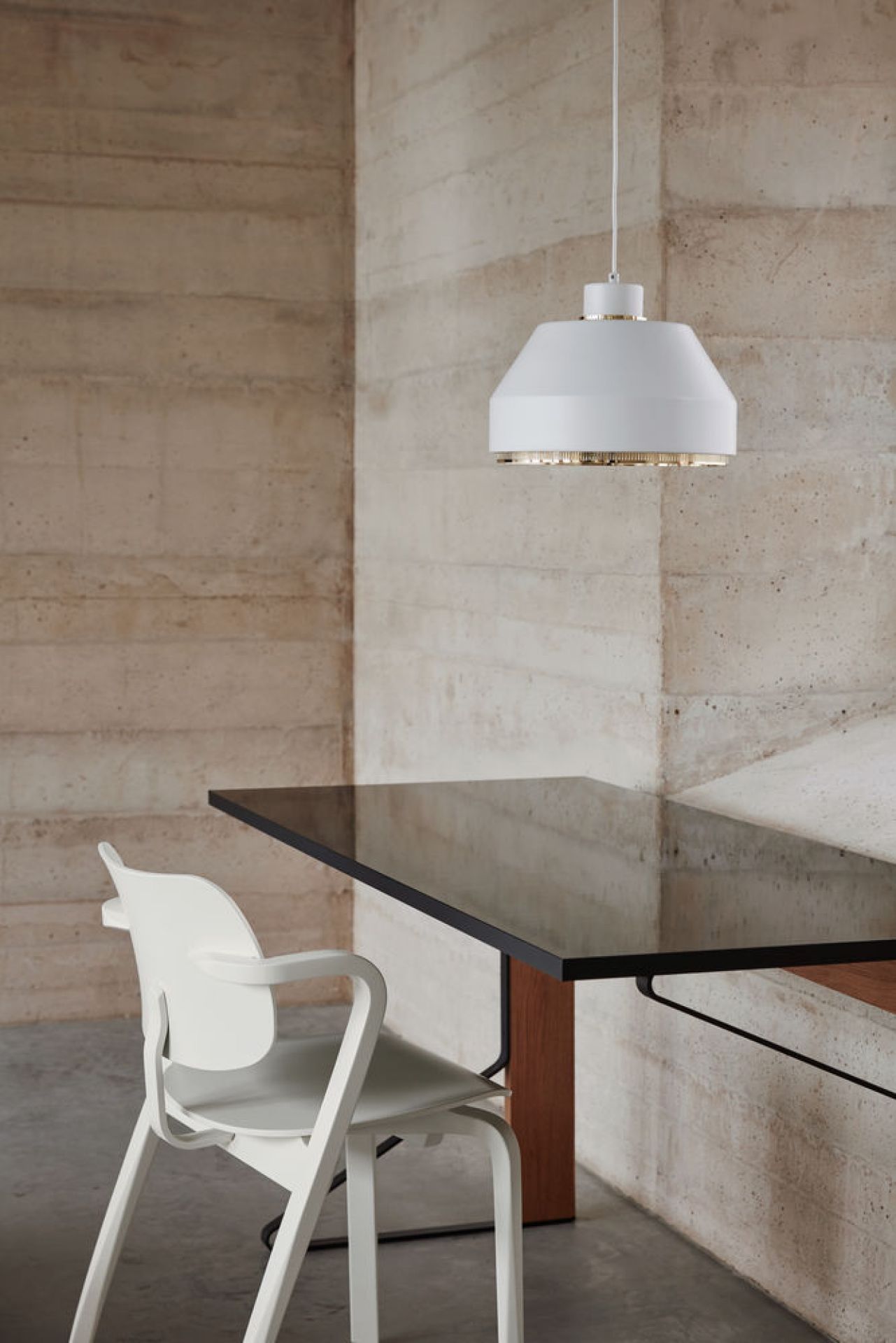 Weiße Artek Pendelleuchte AMA500 über Esstisch und Stuhl, modernes skandinavisches Design.