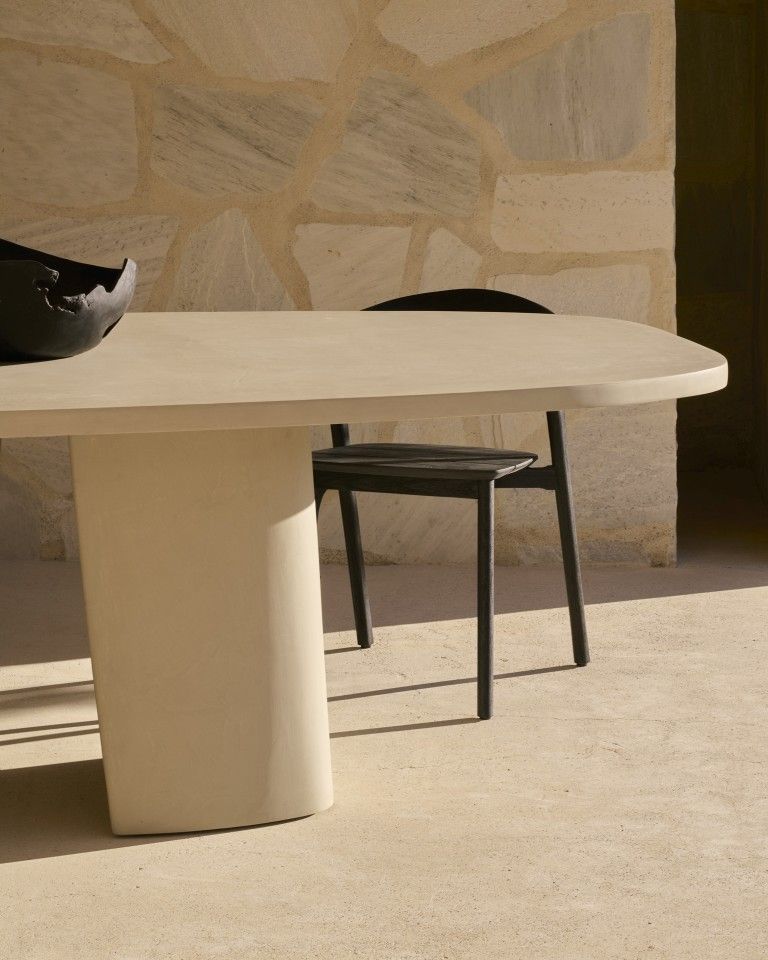 Canyon Outdoor Esstisch von Ethnicraft aus Beton mit Stuhl und Dekoschale im Außenbereich.