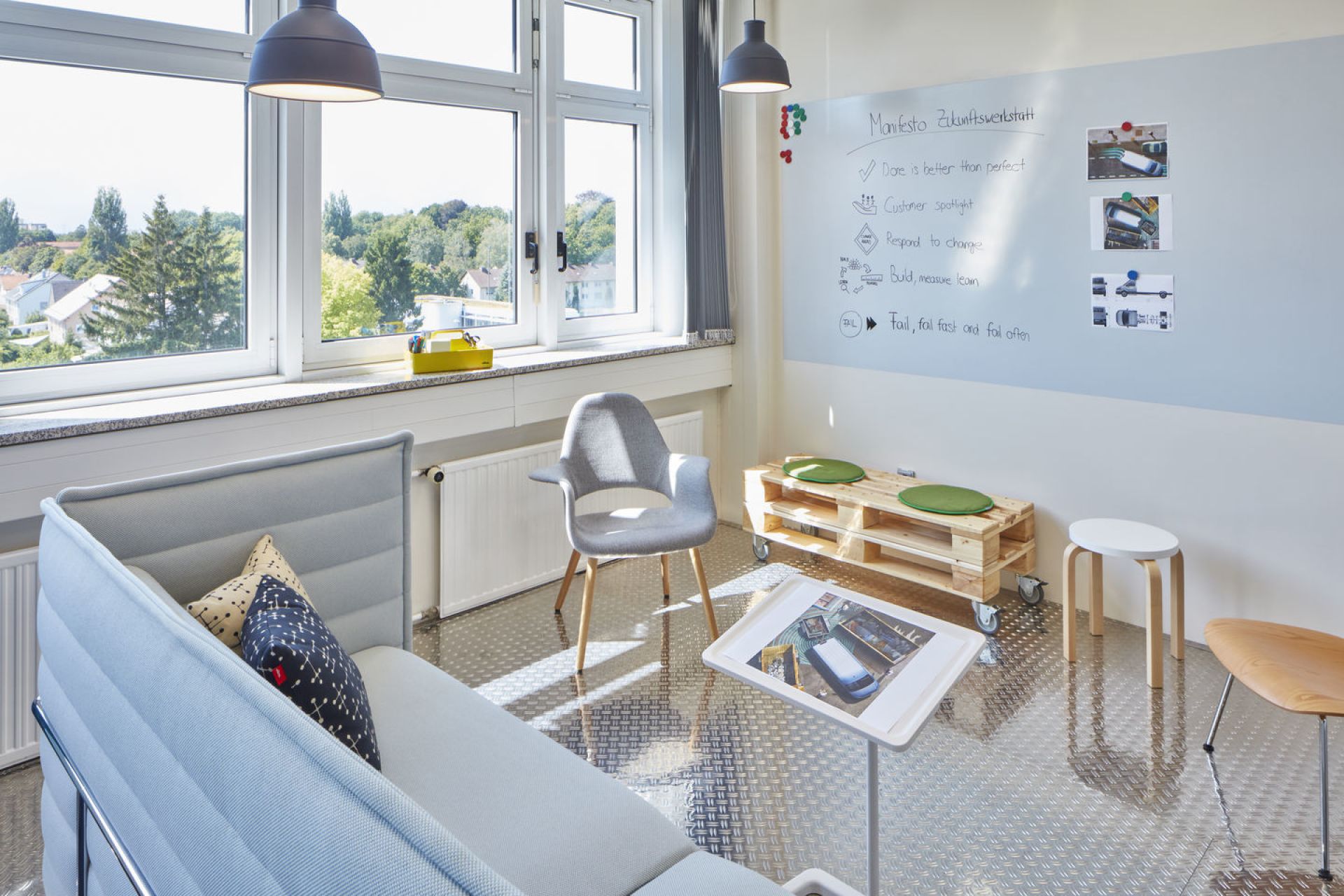 Grauer Organic Chair Stuhl von Vitra in modernem Büro mit Sofa und Whiteboard.