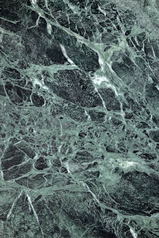 Detailaufnahme der Marmorplatte des Kuyu Marble Couchtisches mit grünen und weißen Maserungen.