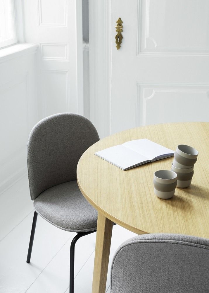 Ace Chair Stuhl von Normann Copenhagen, gepolstert mit grauem Stoff und schwarzen Beinen am Holztisch.