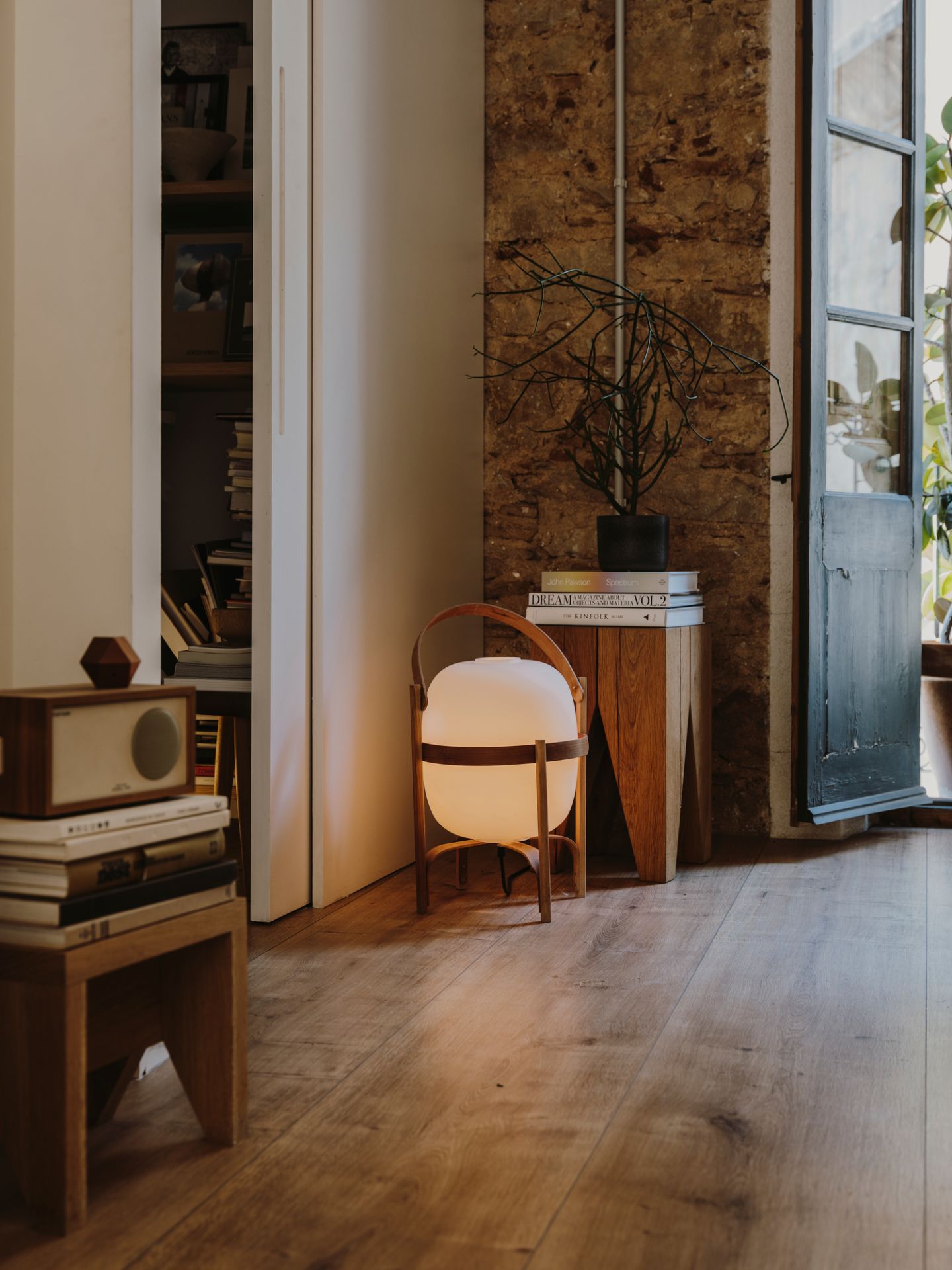 Nahaufnahme der Cesta Tischleuchte von Santa & Cole, die warmes Licht in einem gemütlichen Interieur spendet.
