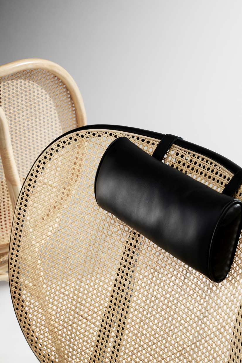Detailaufnahme: NORR11 Nomad Chair Sessel mit Wiener Geflecht und schwarzer Lederkopfstütze, modernes Möbeldesign.