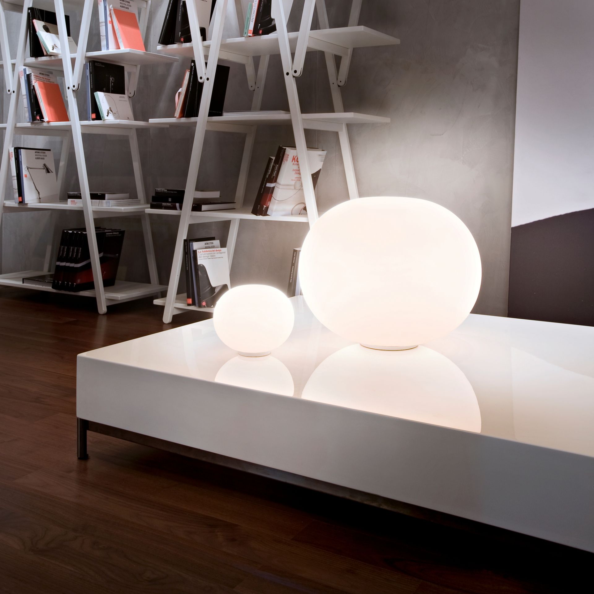 Zwei Glo Ball Tischleuchten von Flos, eine große und eine kleine, auf weißem Tisch.