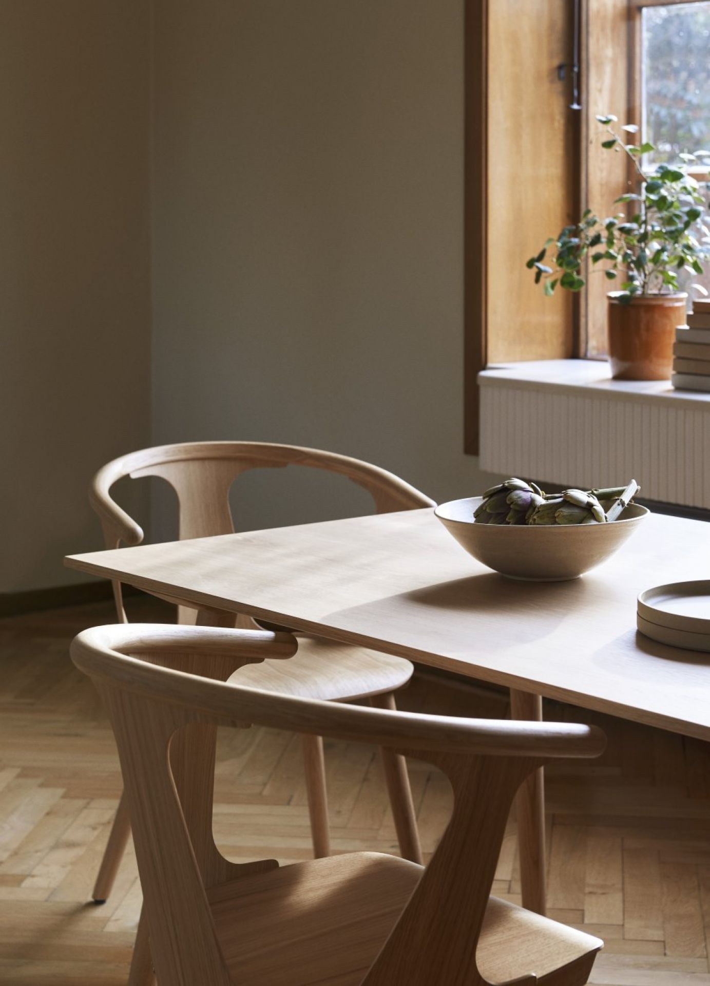 AndTradition In Between Chair SK1 aus Eiche, schwarz lackiert, mit Holztisch und Dekoration.