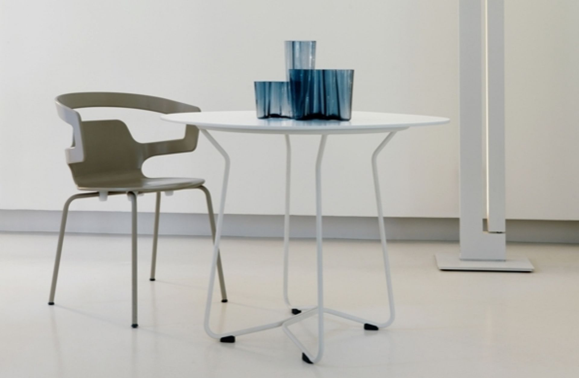 Segesta Chair 500 Alias Stuhl in Olivgrün neben einem weißen runden Tisch mit blauen Vasen.