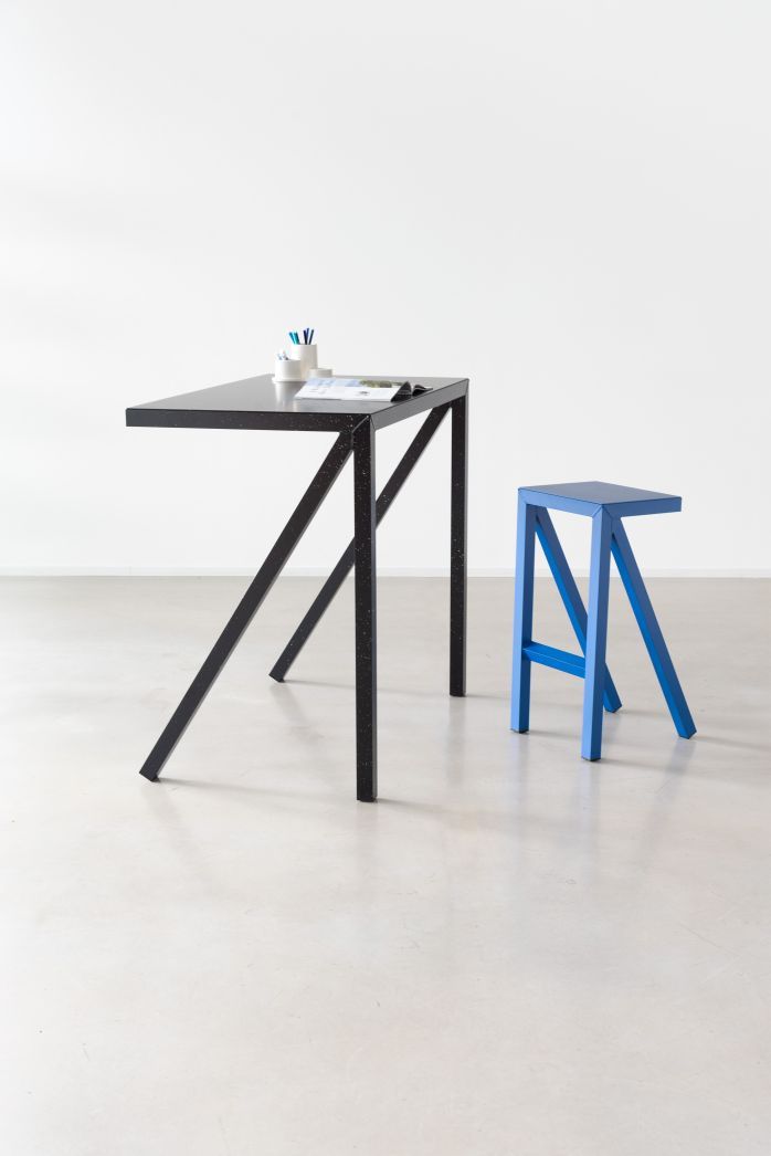 Bureaurama Schreibtisch mit Magis Hocker: Moderner blauer Barhocker und schwarzer Schreibtisch mit minimalistischem Design.