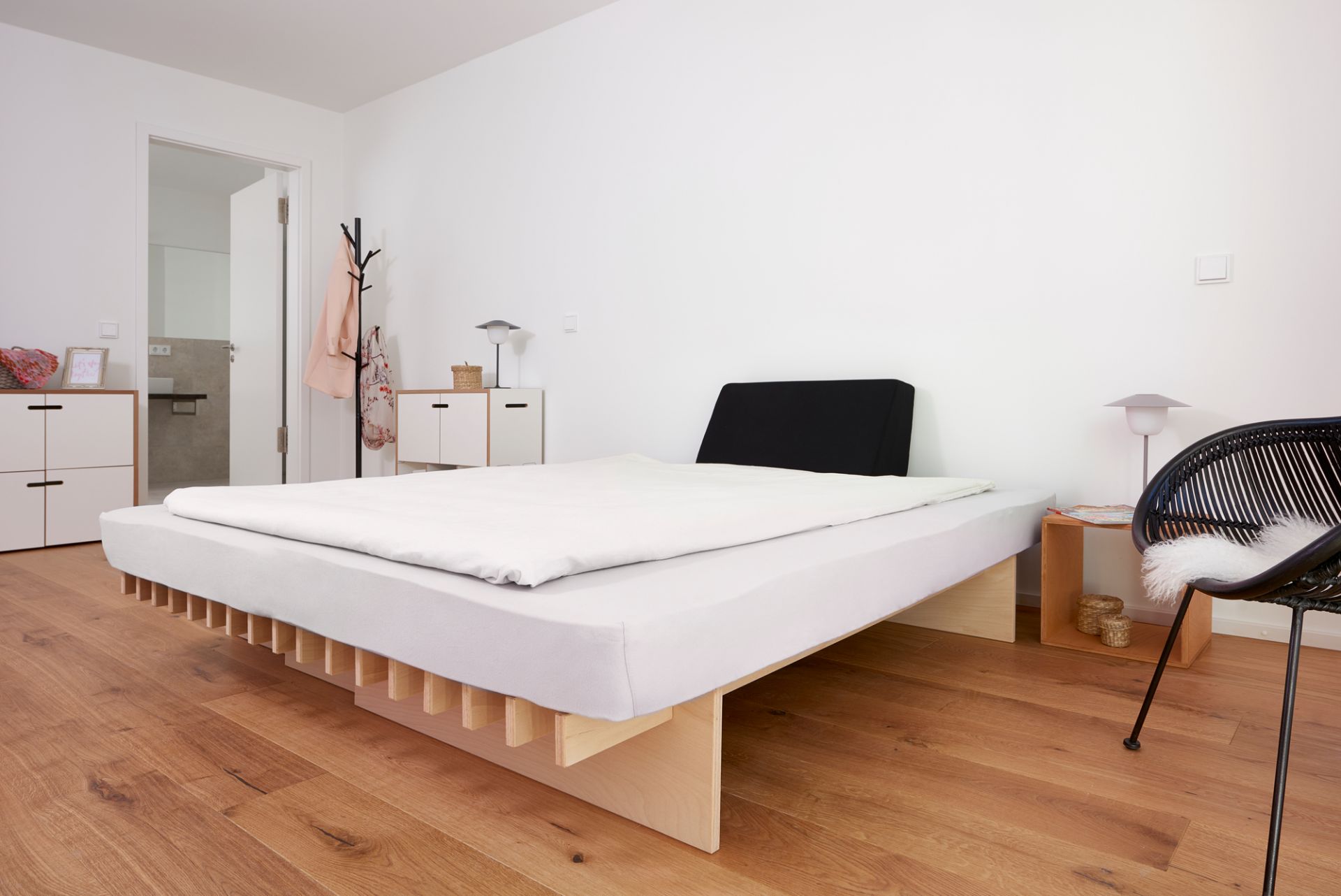 Helles Schlafzimmer mit Ergo Faltmatratze von Tojo auf einem Holzgestell. Ergonomische Matratze für erholsamen Schlaf.