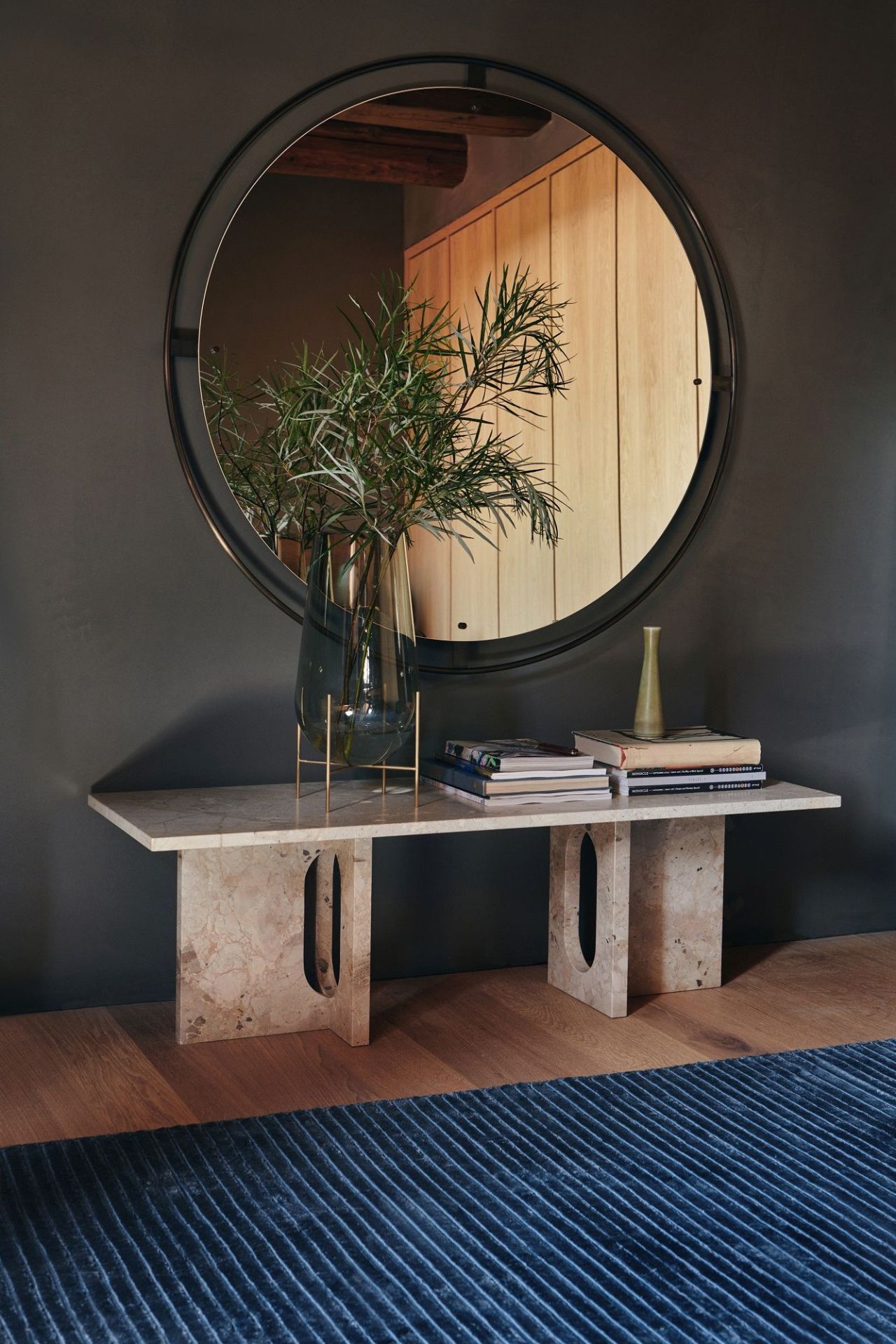 Audo Copenhagen Nimbus Mirror über Marmorkonsole mit Dekoration in modernem Interieur.