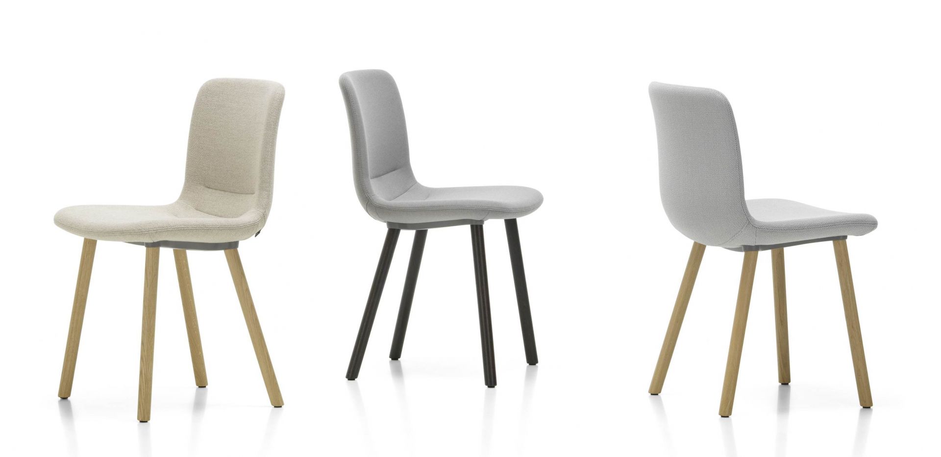 Drei Vitra Hal Soft Wood Stühle in Beige und Grau mit Holz- und Metallbeinen.