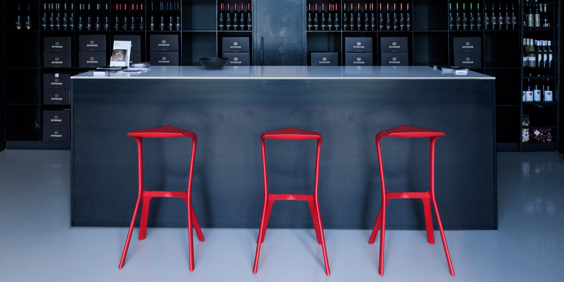 Drei rote Miura Barhocker vor einer Bar. Design Hocker für Küche und Gastronomie.