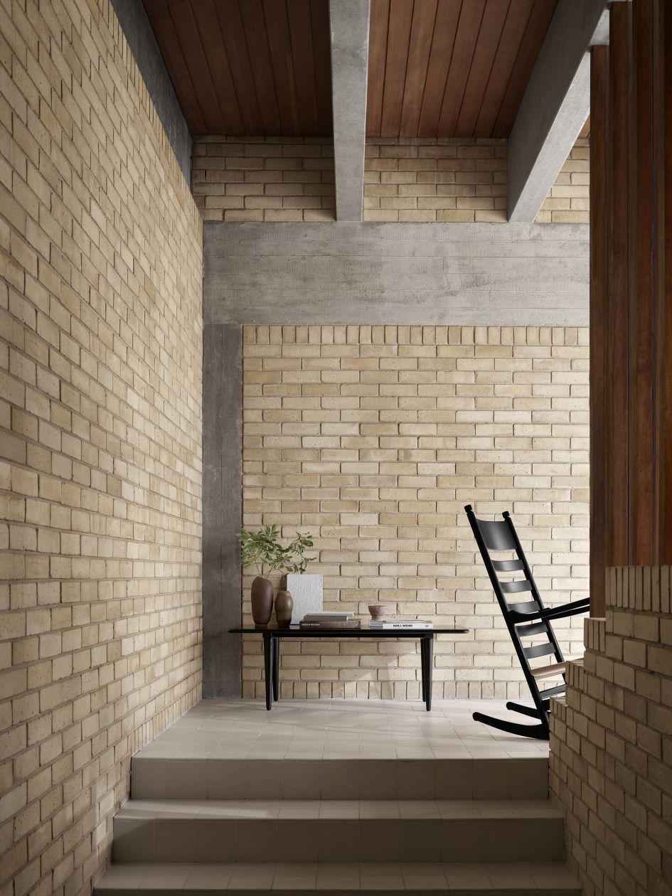 Schwarzer CH45 Schaukelstuhl von Carl Hansen & Søn in modernem Interieur mit Backsteinwand und minimalistischem Tisch.