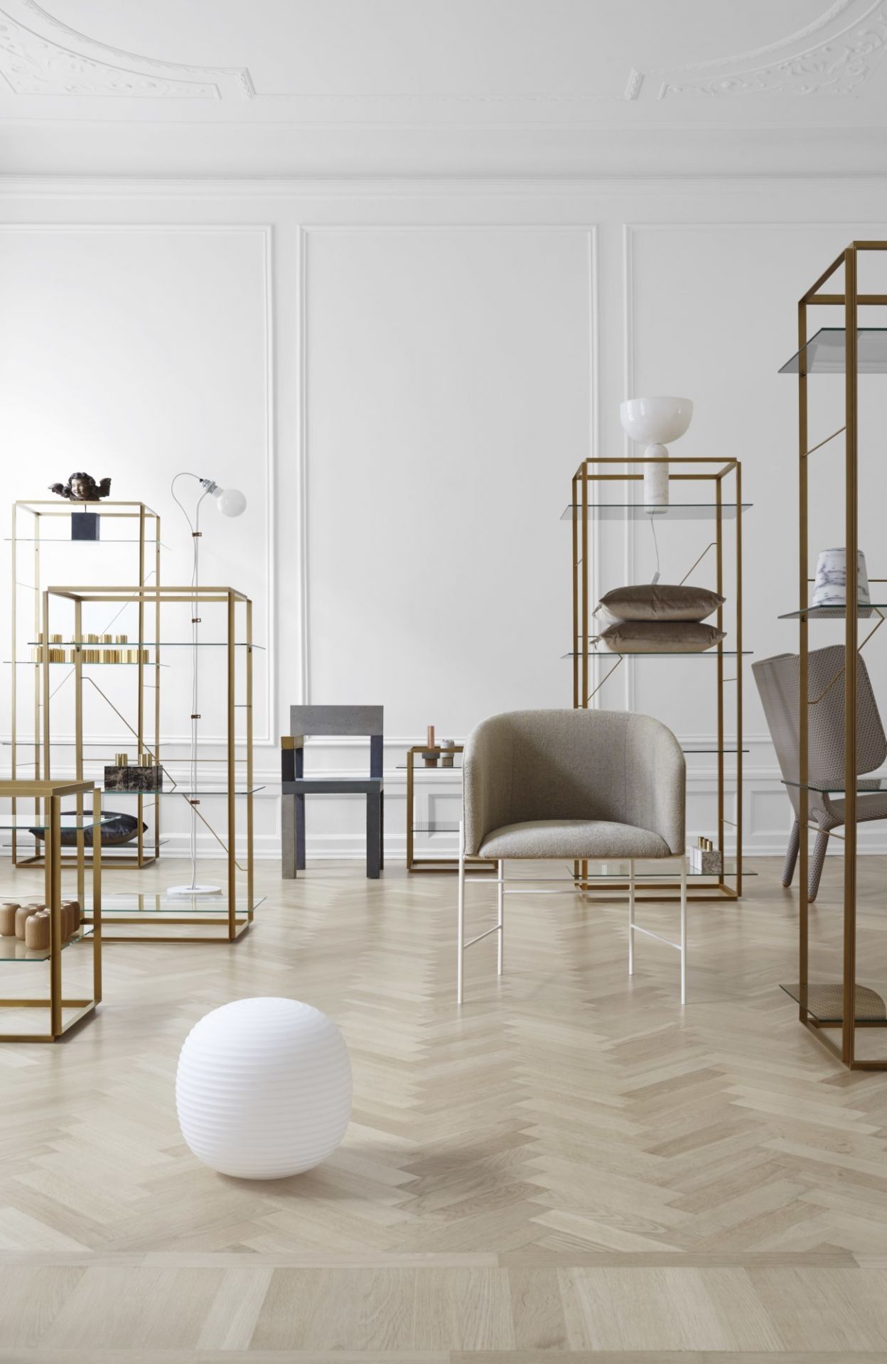 Weiße Kizu Tischleuchte von New Works in modernem Interieur mit Regalen und Stühlen.