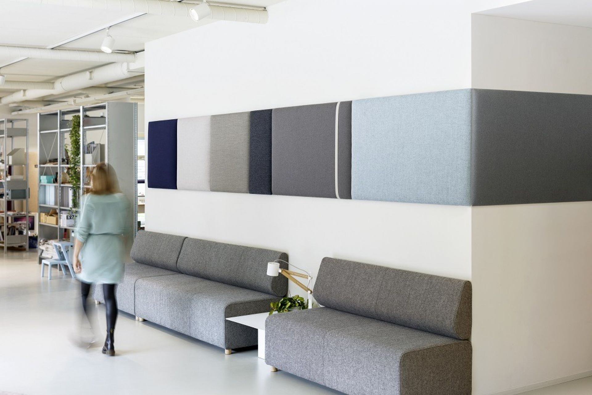 Büro mit Cascando Pillow Grid Wandpaneelen in verschiedenen Farben über grauen Sofas.