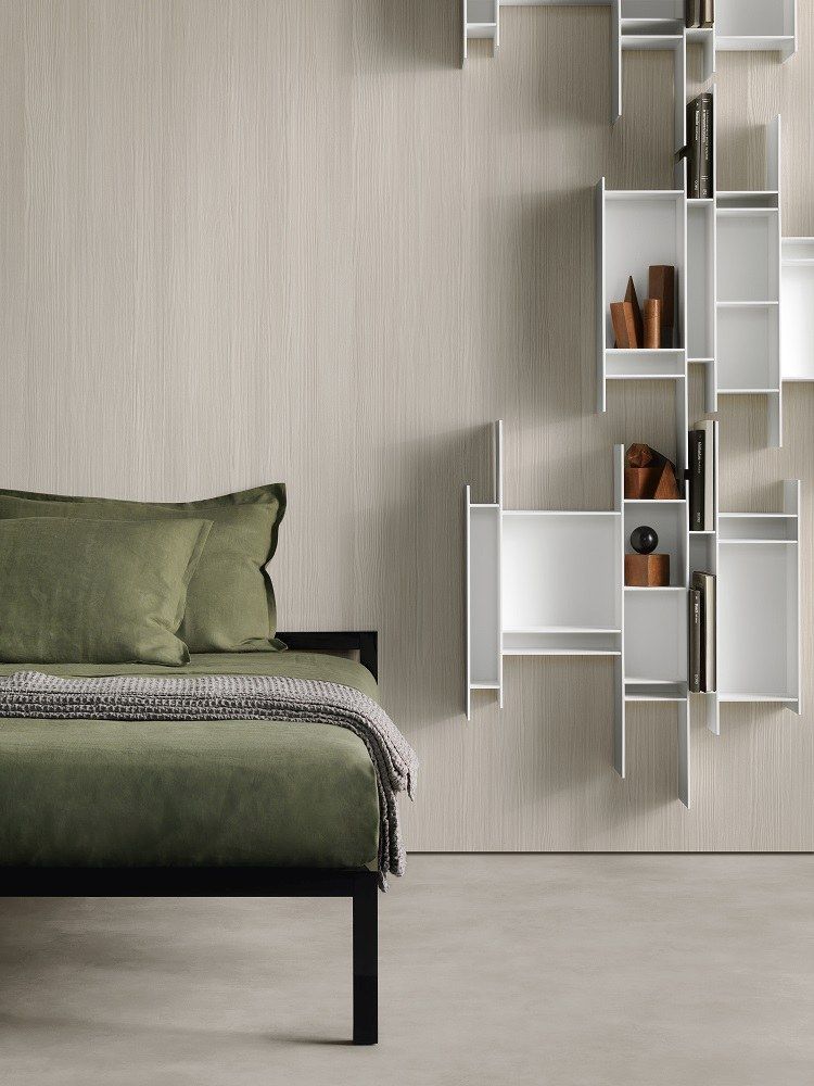 Modernes Schlafzimmer mit Aluminium Bettgestell, grüner Bettwäsche und weißem Wandregal von MDF Italia.