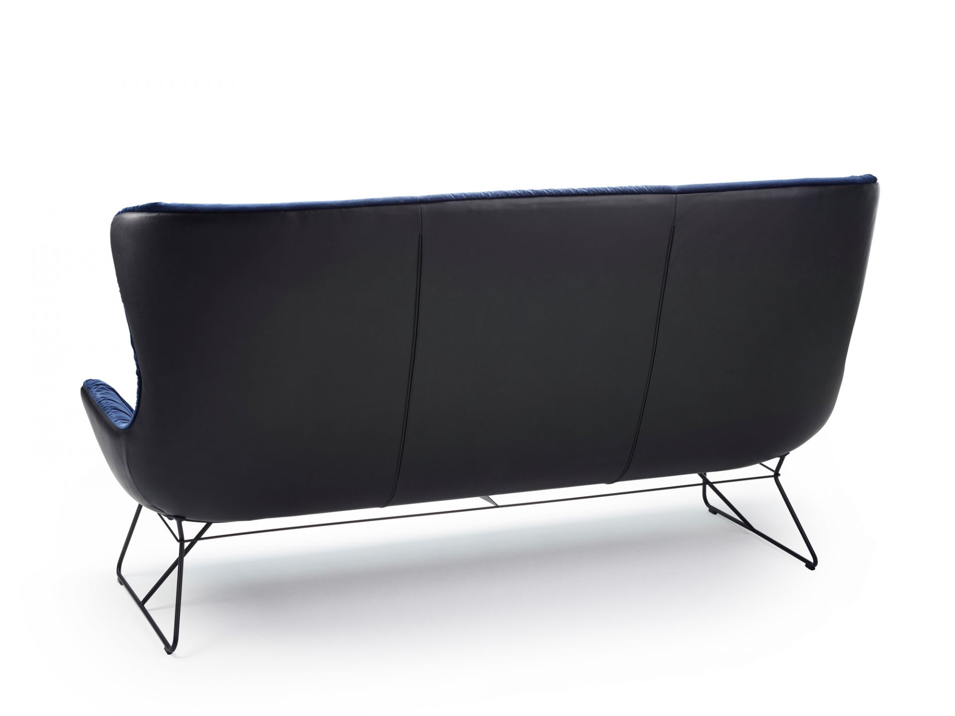 Rückansicht der Leya Couch von Freifrau Manufaktur mit schwarzem Leder und blauem Samt.
