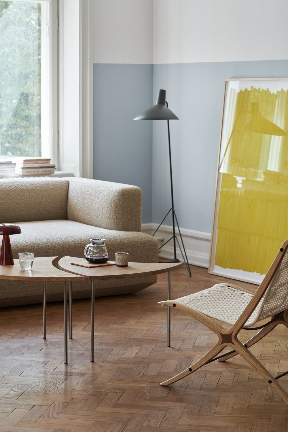 Wohnzimmer Interieur mit beigem Develius Sofa von AndTradition, Holztisch, Design Stuhl und Stehlampe.
