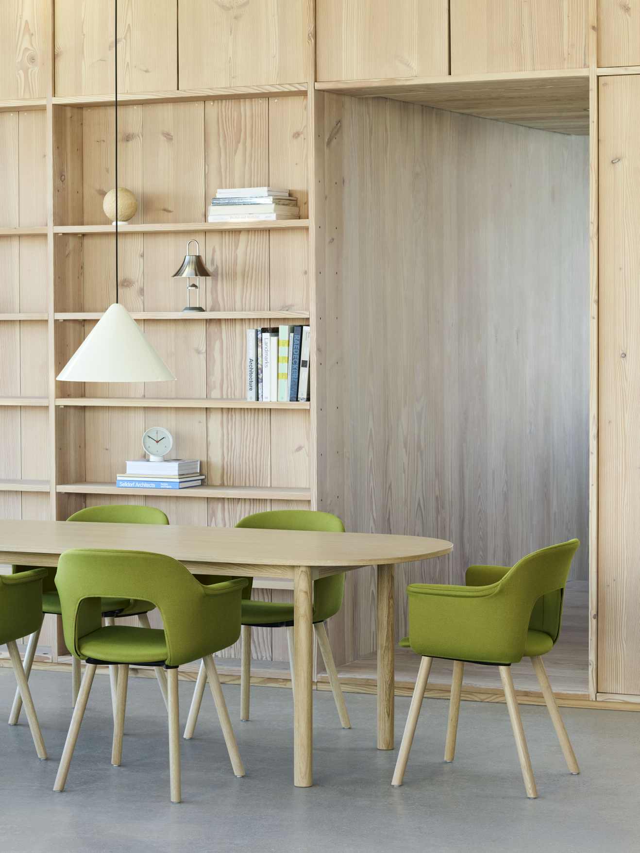 Annex Table Oblong Esstisch von Hay, oval, aus hellem Holz, mit grünen Stühlen in modernem Esszimmer.