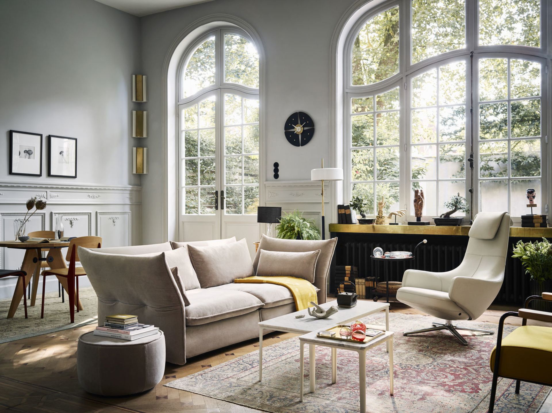 Helles Wohnzimmer mit Vitra Standard Stühlen am Esstisch und beigem Sofa mit Kissen.